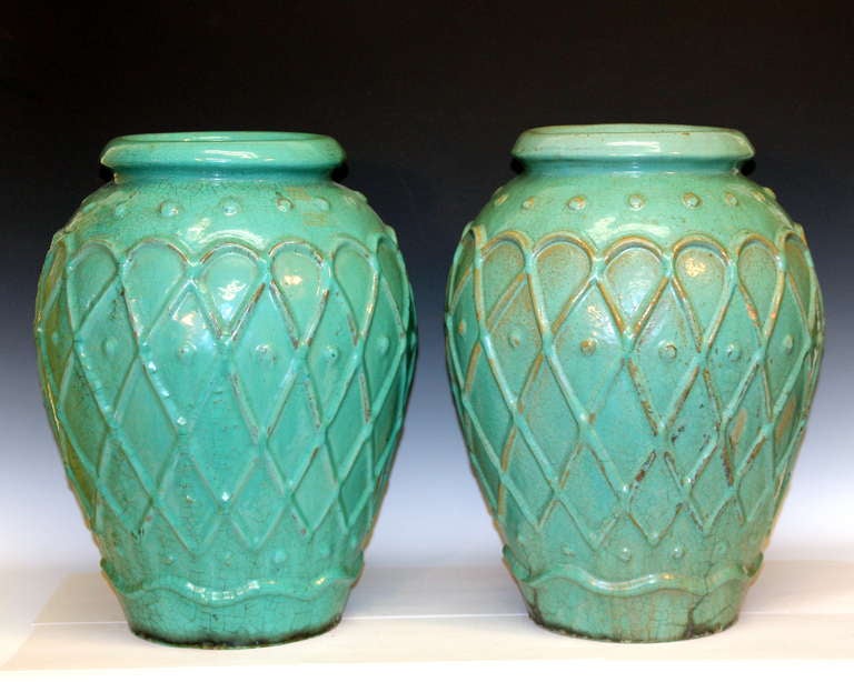 Large pair of garden urns by the Galloway Terracotta Company of Philadelphia in green/turquoise crackle glaze, circa early 20th century. One with impressed mark inside mouth rim. Measures: 20