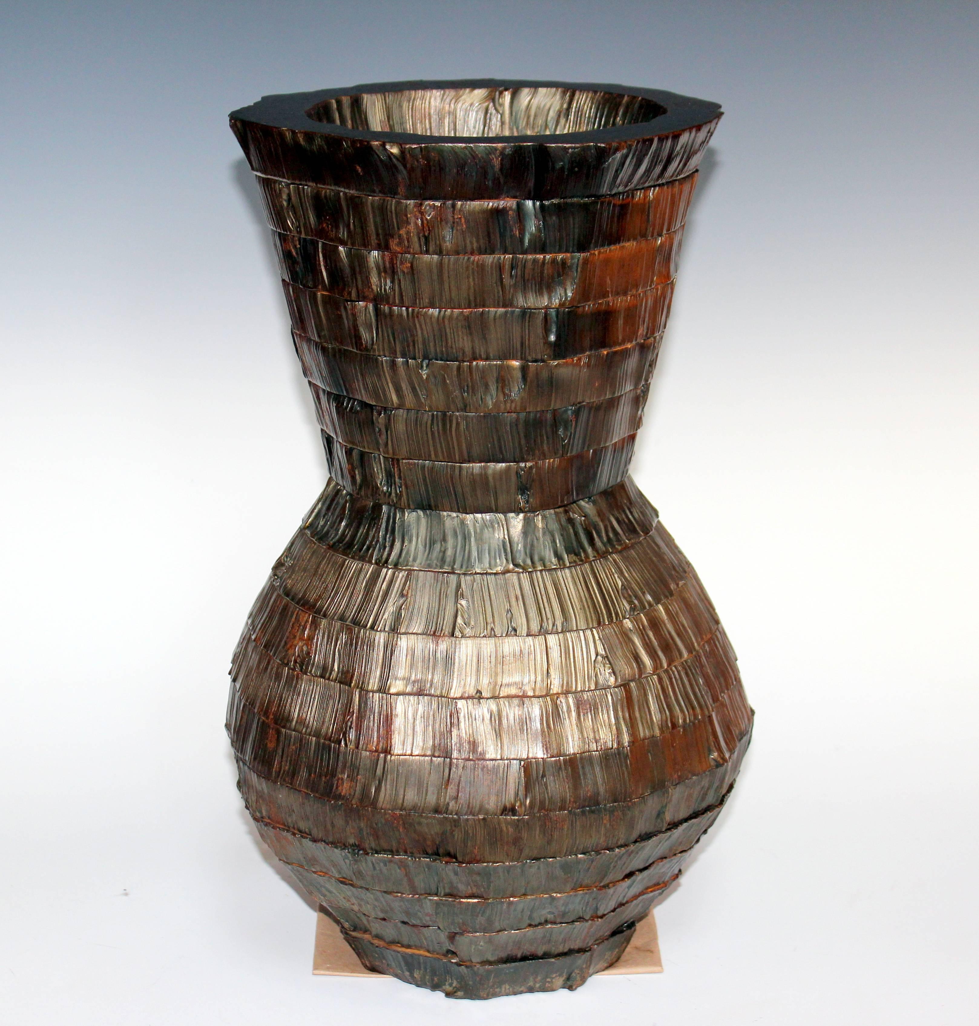 Stark cut steel vase by sculptor Ernest Shaw. Assembled and forged from individually cut bands of steel up to an inch and a half thick with a tree bark texture. Organic and strong. 17