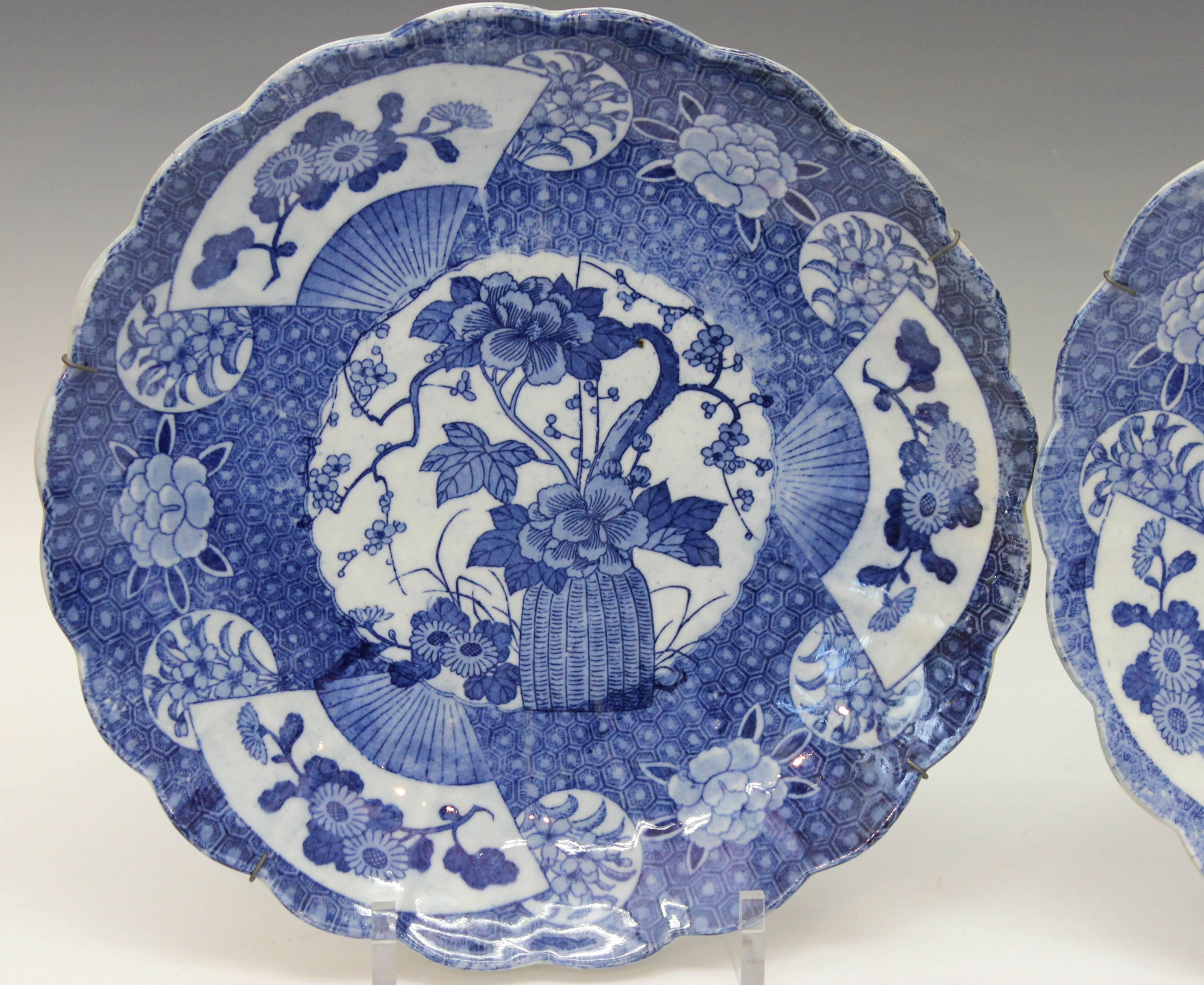 Pair Japanese porcelain chargers with foliated rims decorated with blue and white transfer designs, circa 1890's. With wire hangers. 14 1/2