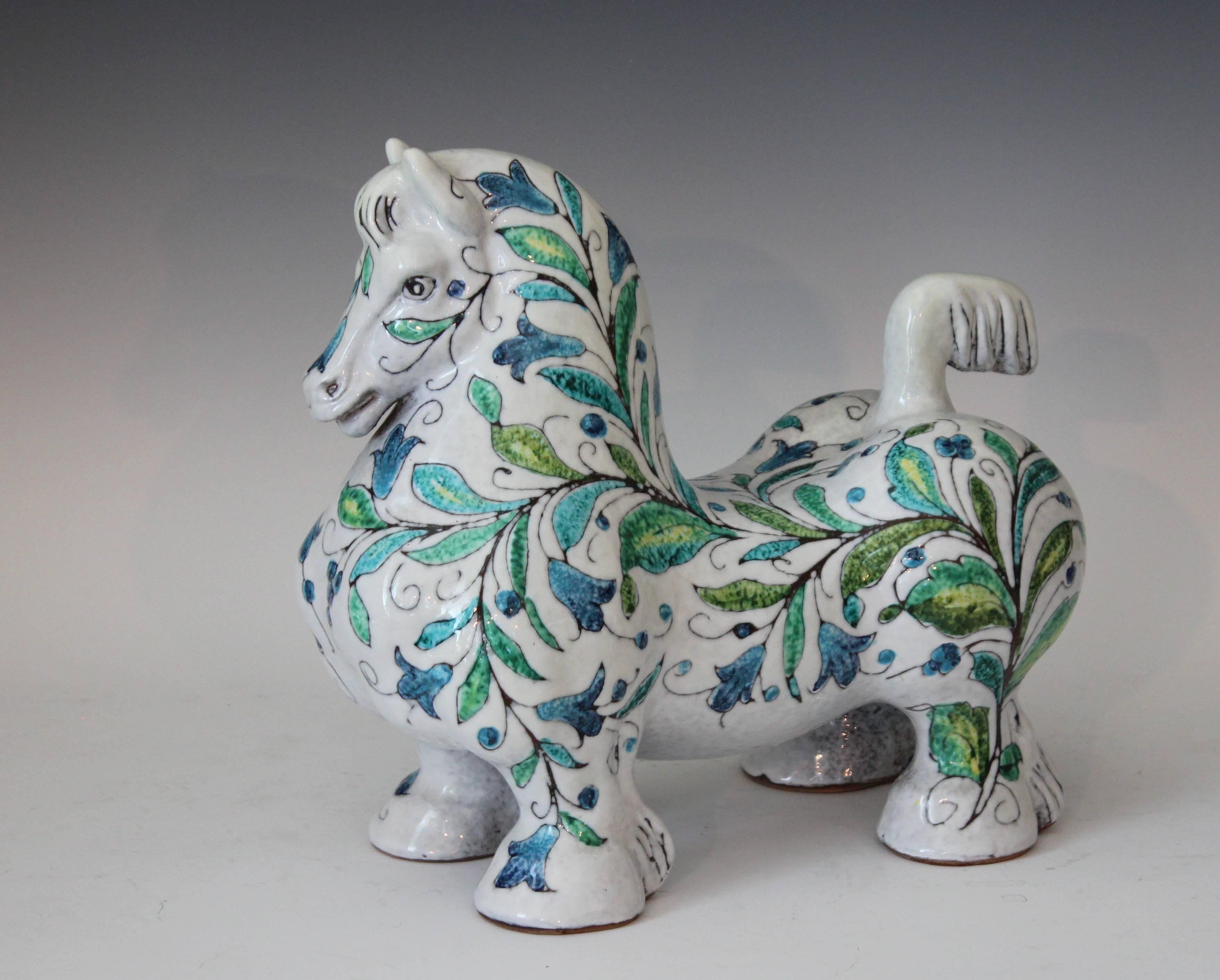 Large vintage Italian pottery stylized horse, circa 1960's. Well fed and painted in thick glaze with blue and green floral decor on a mottled white ground. From the Mancioli Pottery of the Florence region.  Measures: 11 1/4