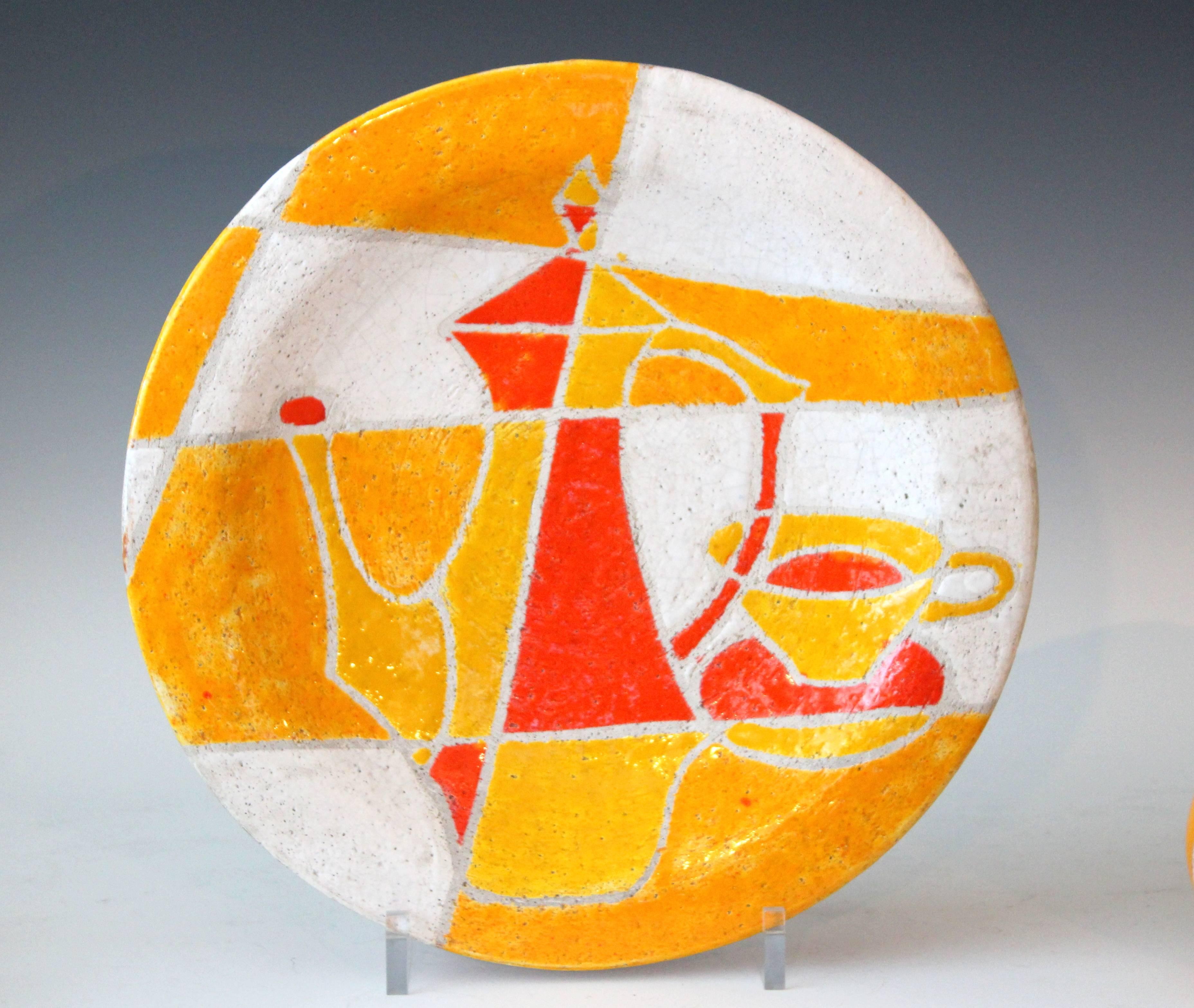 Striking Bitossi charger decorated with a hybrid cubism still life in areas of saturated sunny glazes separated by a wax resist outline. Design number 1841 dated to 1959-1961. Sturdy steel wire for hanging. 15 3/4" diameter, 2 1/2" deep.