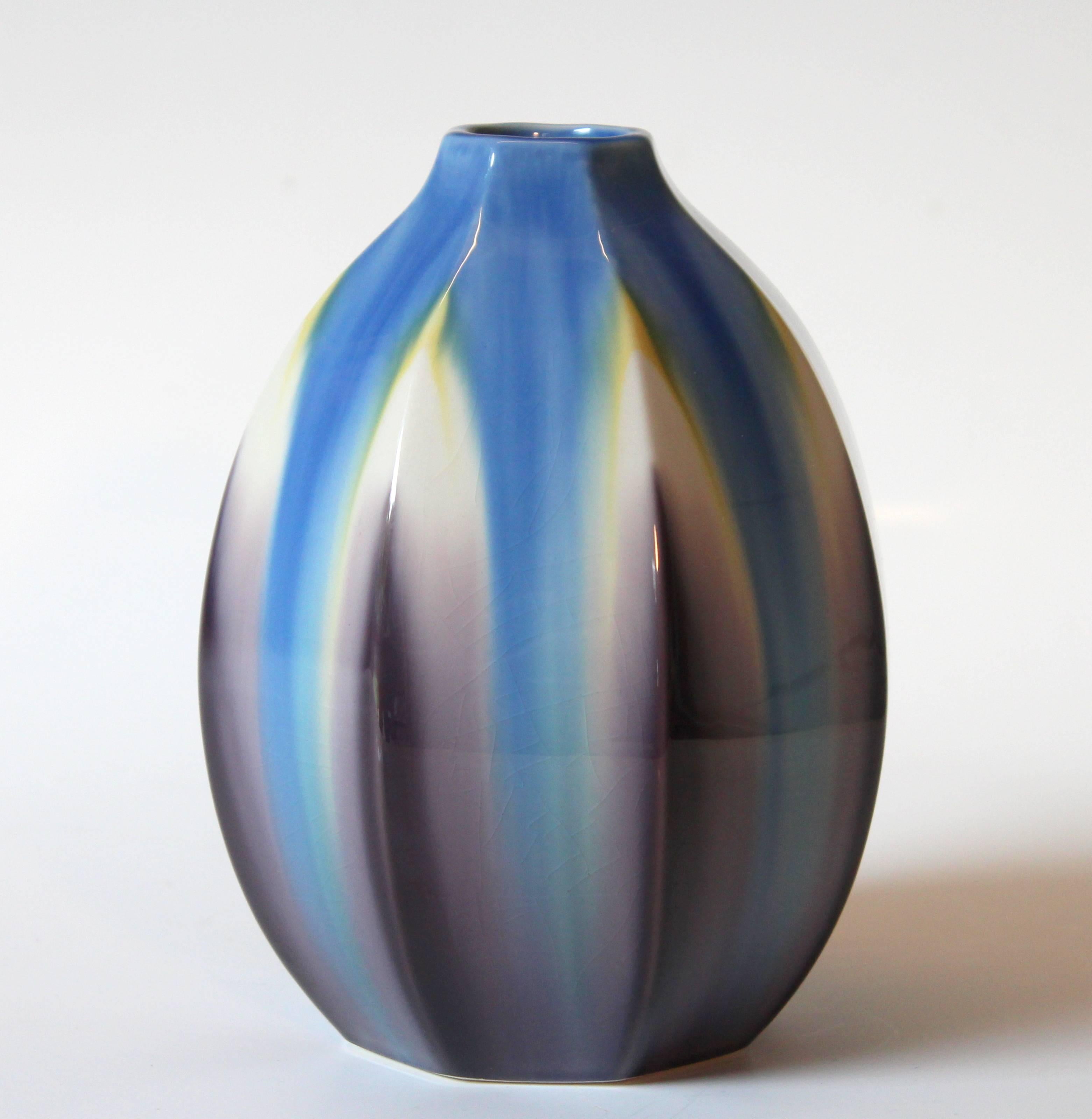 Octagonal Kutani studio porcelain vase by master potter, Hiroshi Shibata. Hand formed and carved into even facets and glazed in Yusai technique with subtle gradation between the different colored glazes, circa 1990. Finely hand-painted 