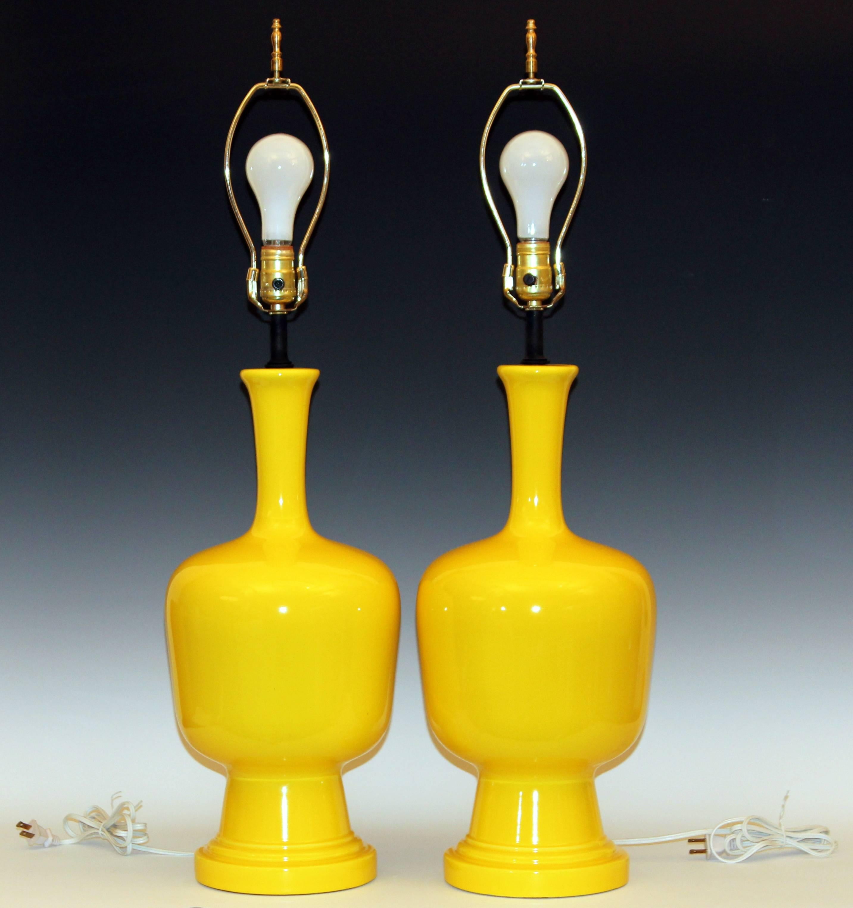 Pair of vintage pottery lamps in pleasant organic form and bright yellow glaze, circa 1970. Sure to brighten or cheer up any room. New wiring, reconditioned hardware. Measures: 33" high overall, 20" to top of pottery, 9" diameter.