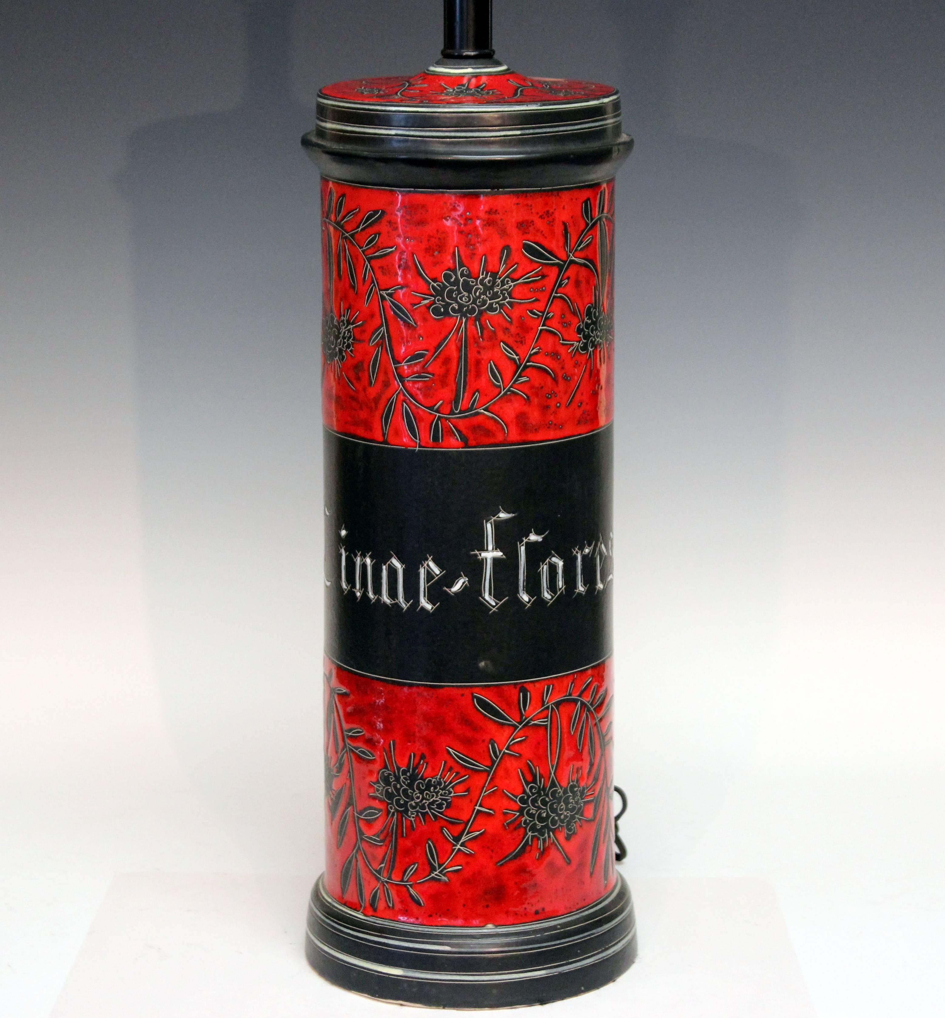 Great Alvino Bagni studio herbal apothecary jar lamp in exceptional decoration with the white tracery etched away from the black ground and the rich red and white enameling added. Chininum is the plant that Quinine is synthesized from. Cinae Flores