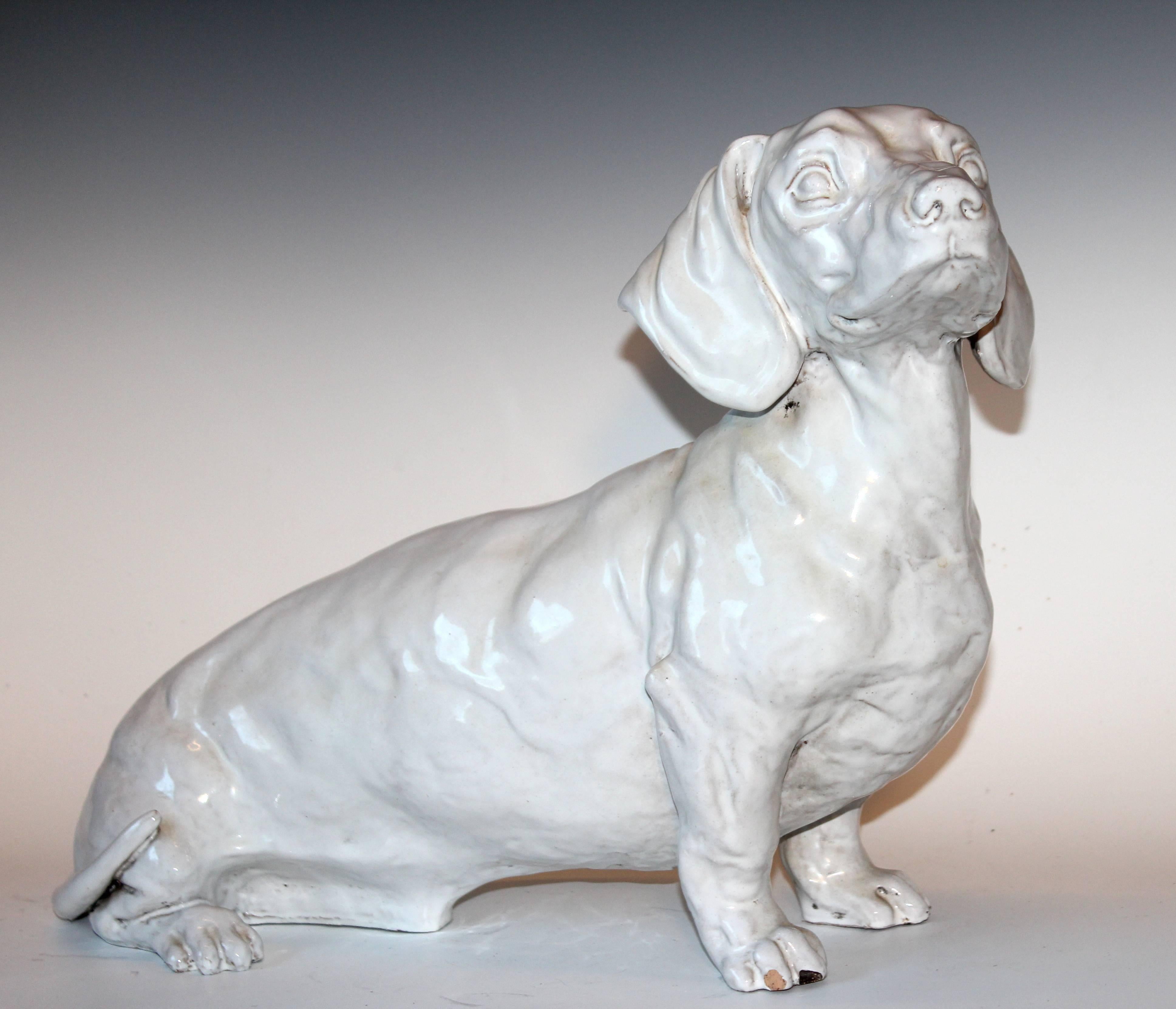 Large Italian pottery Dachshund figure half sitting with pensive expression. Circa mid-20th century. Heavy press molded piece. 22