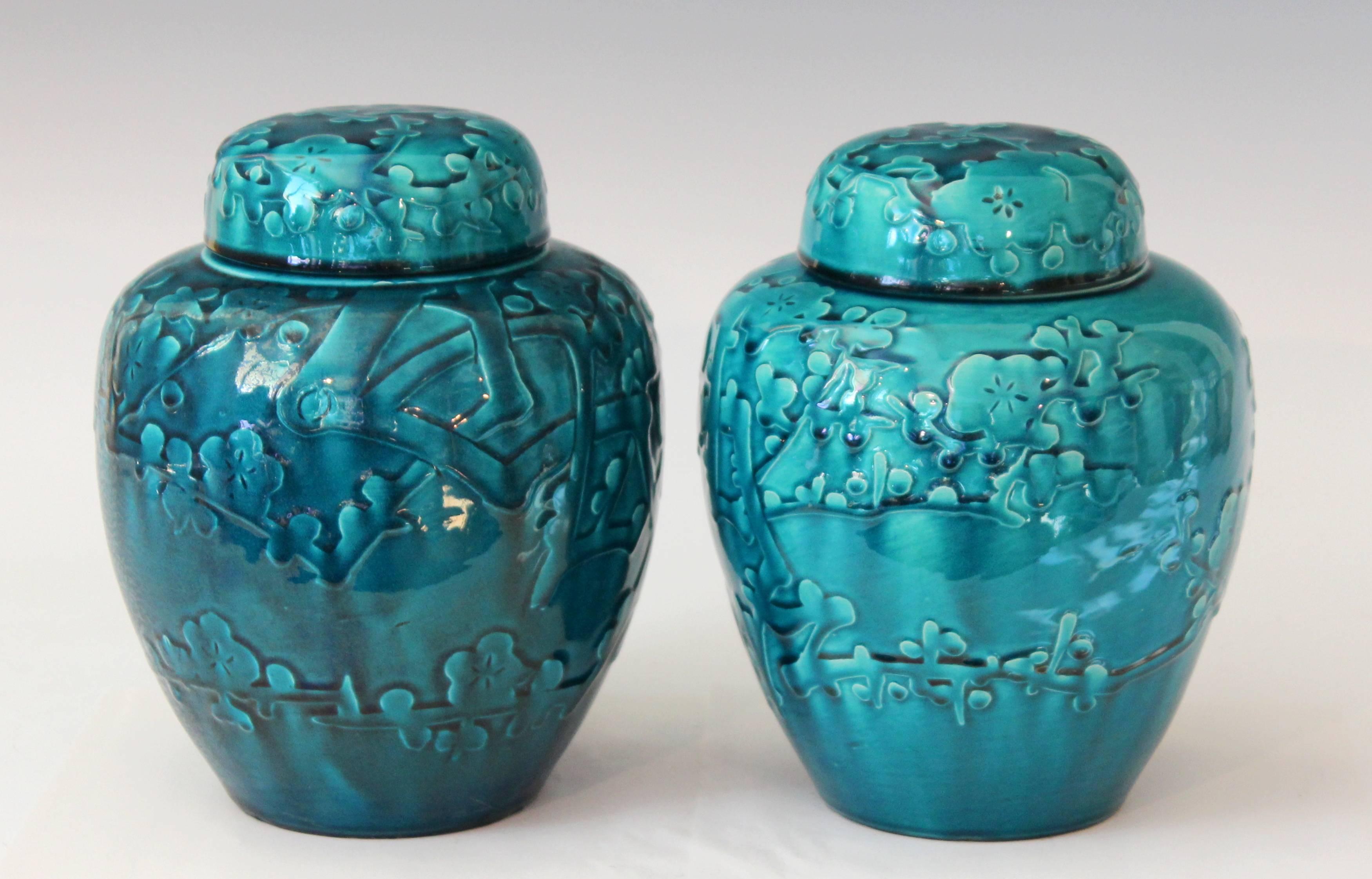 Pair of Awaji ginger jars and covers decorated with applied and incised prunus blossoms highlighted with a deep turquoise monochrome glaze, circa 1930. Impressed export, kiln, and potter's marks. Measures: 9" high, 7" diameter. Excellent