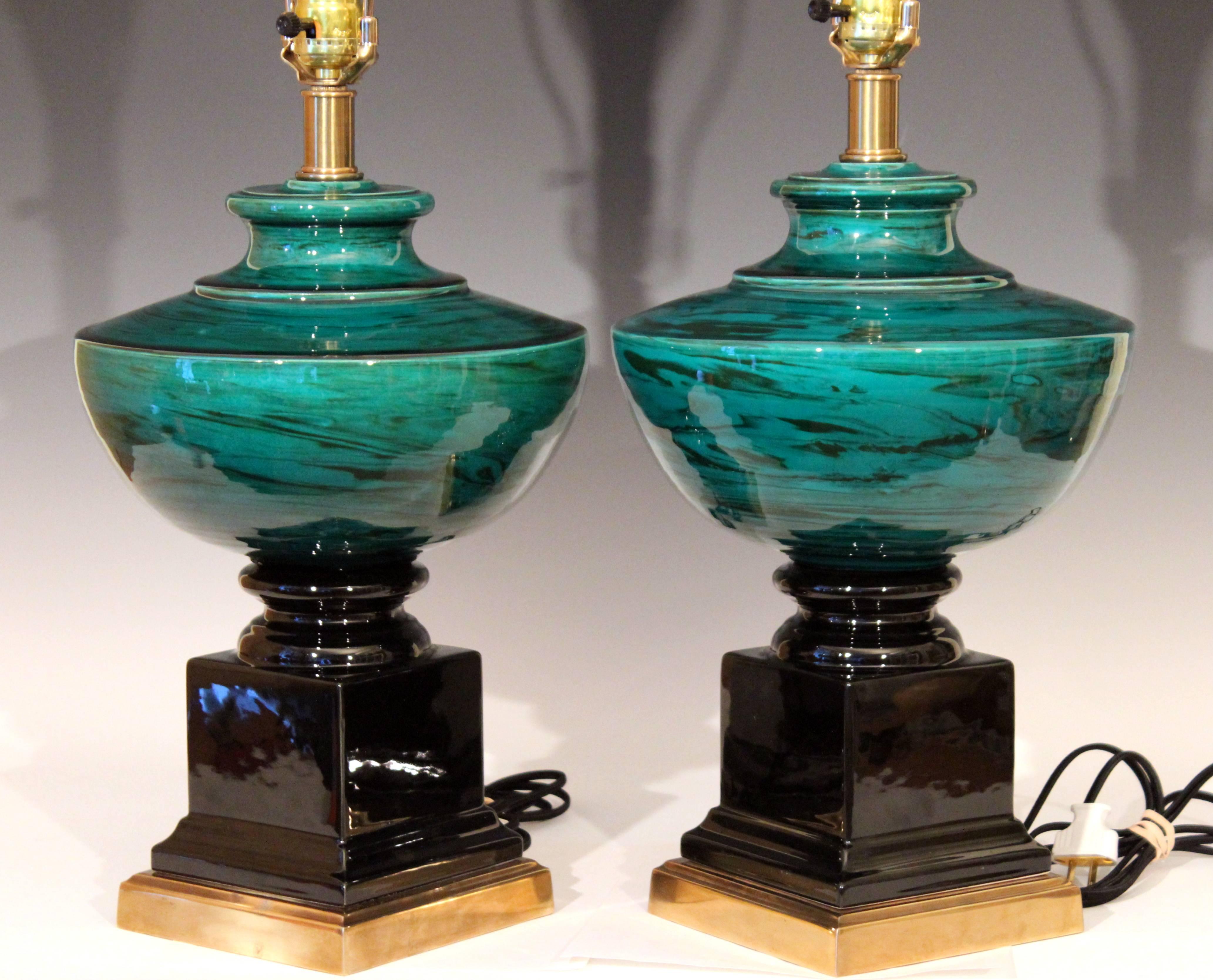 Sleek pair of vintage Bitossi pottery lamps in Classic Georgian form. Reinvigorated to striking effect with hand-turned green marbleized urns and separate gloss black molded pedestals, circa early 1980s. Measures: 29" high overall, 16" to
