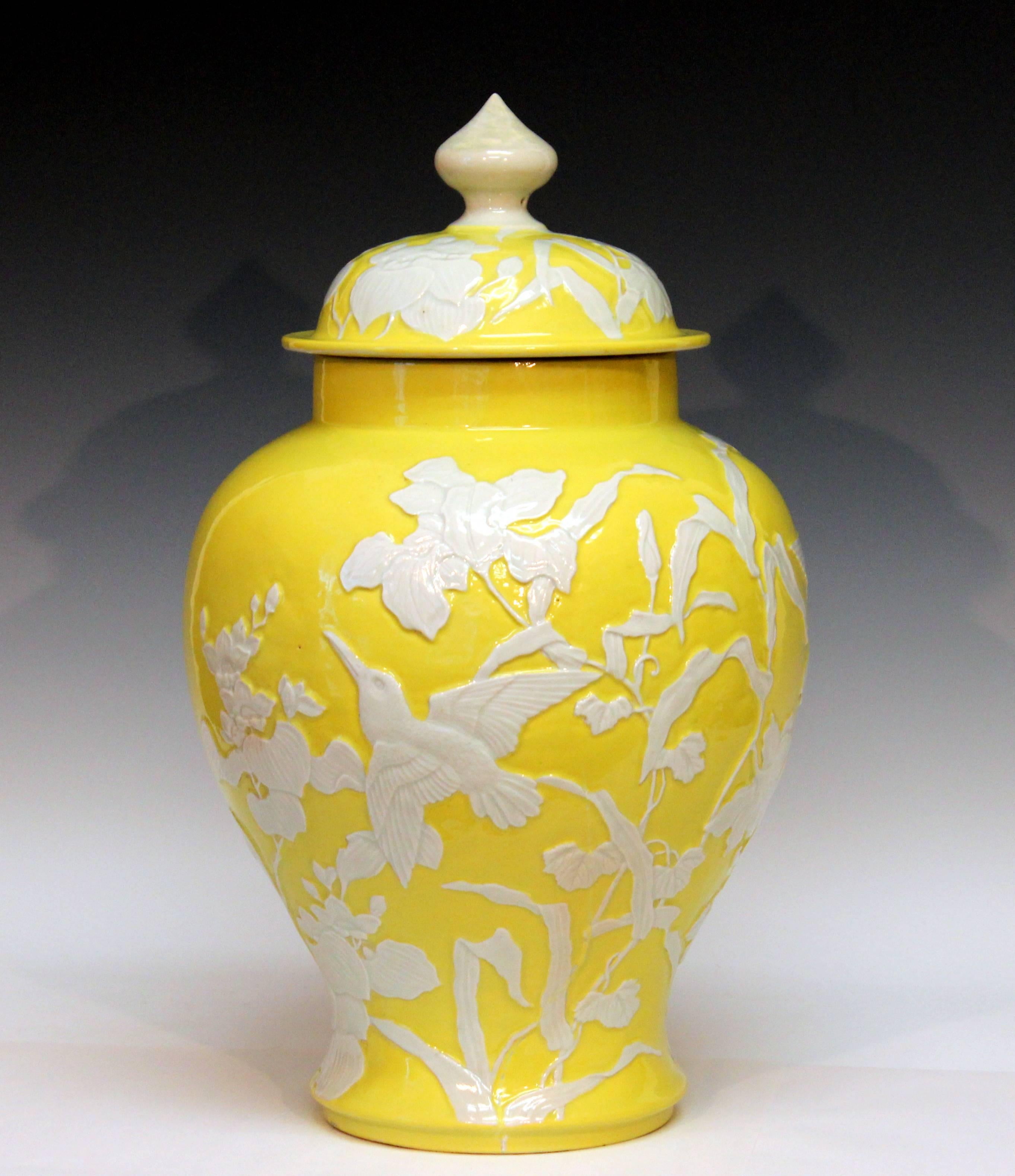 Large Japanese studio porcelain covered vase with finely carved decoration of birds amidst foliage set against a cheerful yellow ground, circa 1910. Measures: 18 1/2" high, 11 1/2" diameter. Excellent condition, repair to finial, firing