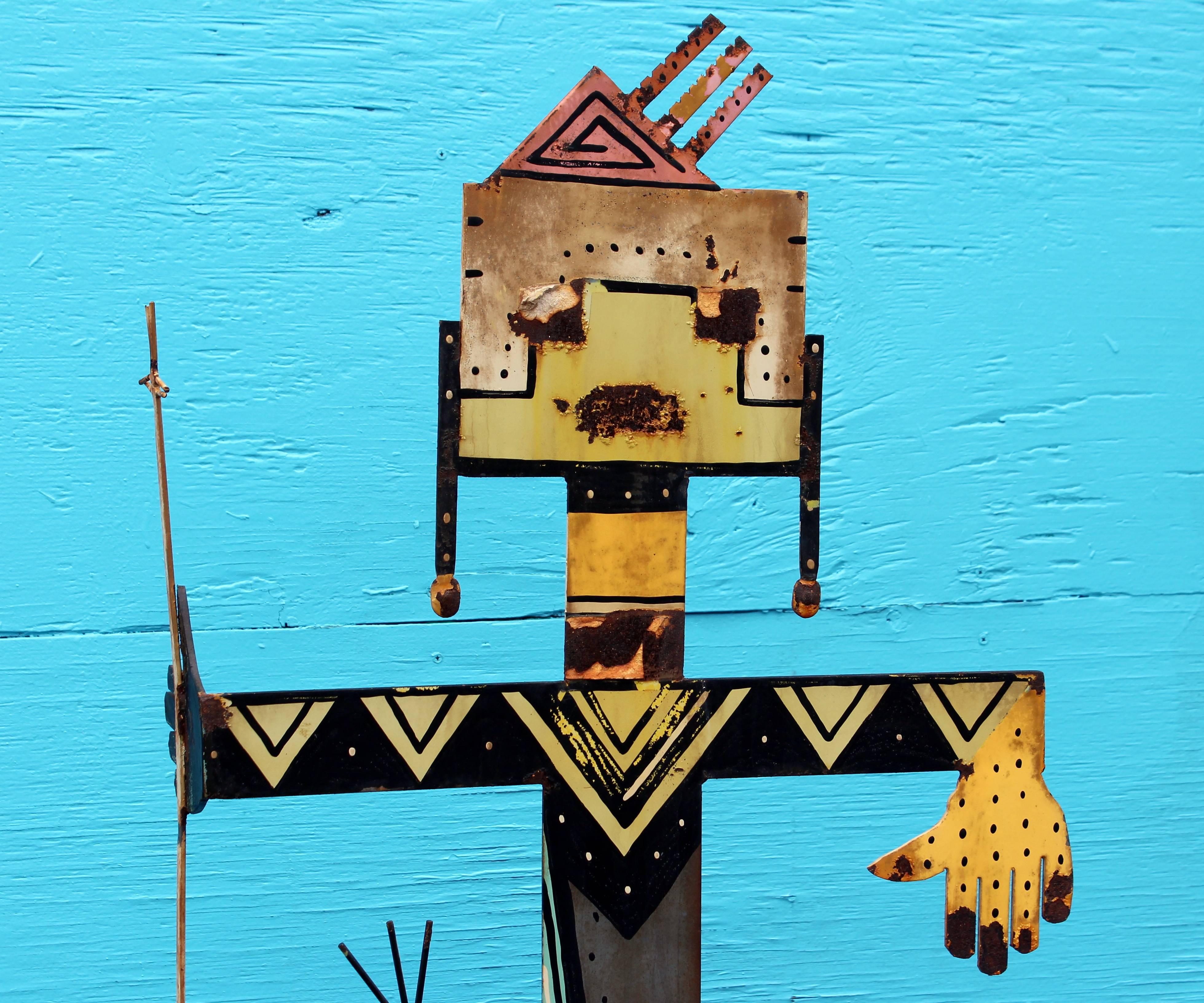 Vintage painted steel sculpture of a Hopi style shamanistic standing figure, circa late 20th century. Depicted standing on a heavy base with two pairs of hands and holding ritual implements and painted on both sides in geometric decor. Lively piece