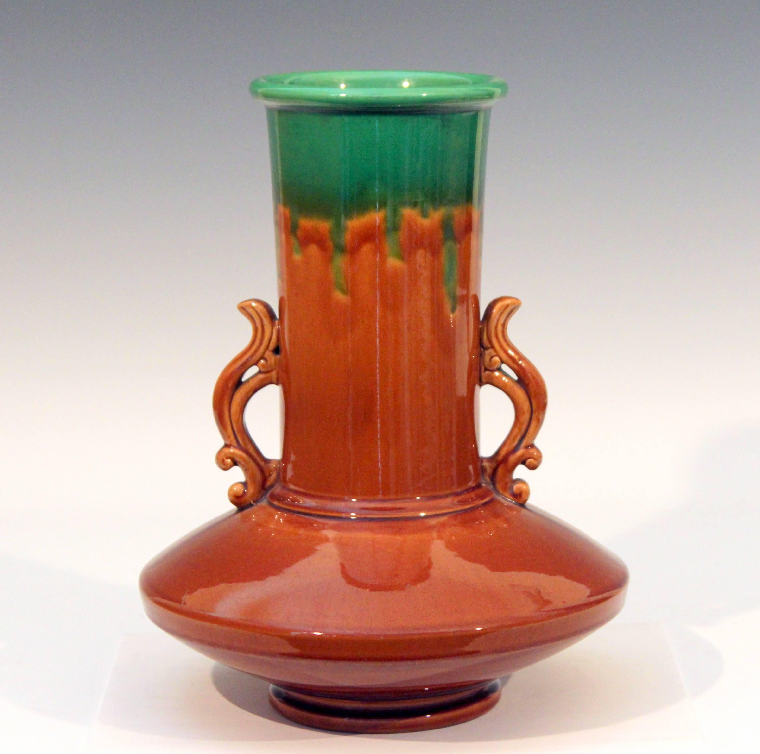 Awaji vase in Art Deco form with compressed saucer base and little flame like handles along the cylindrical neck in even, green over brown drip glaze, circa 1920s. Nice details with separately articulated foot, body, and neck. The little flaming