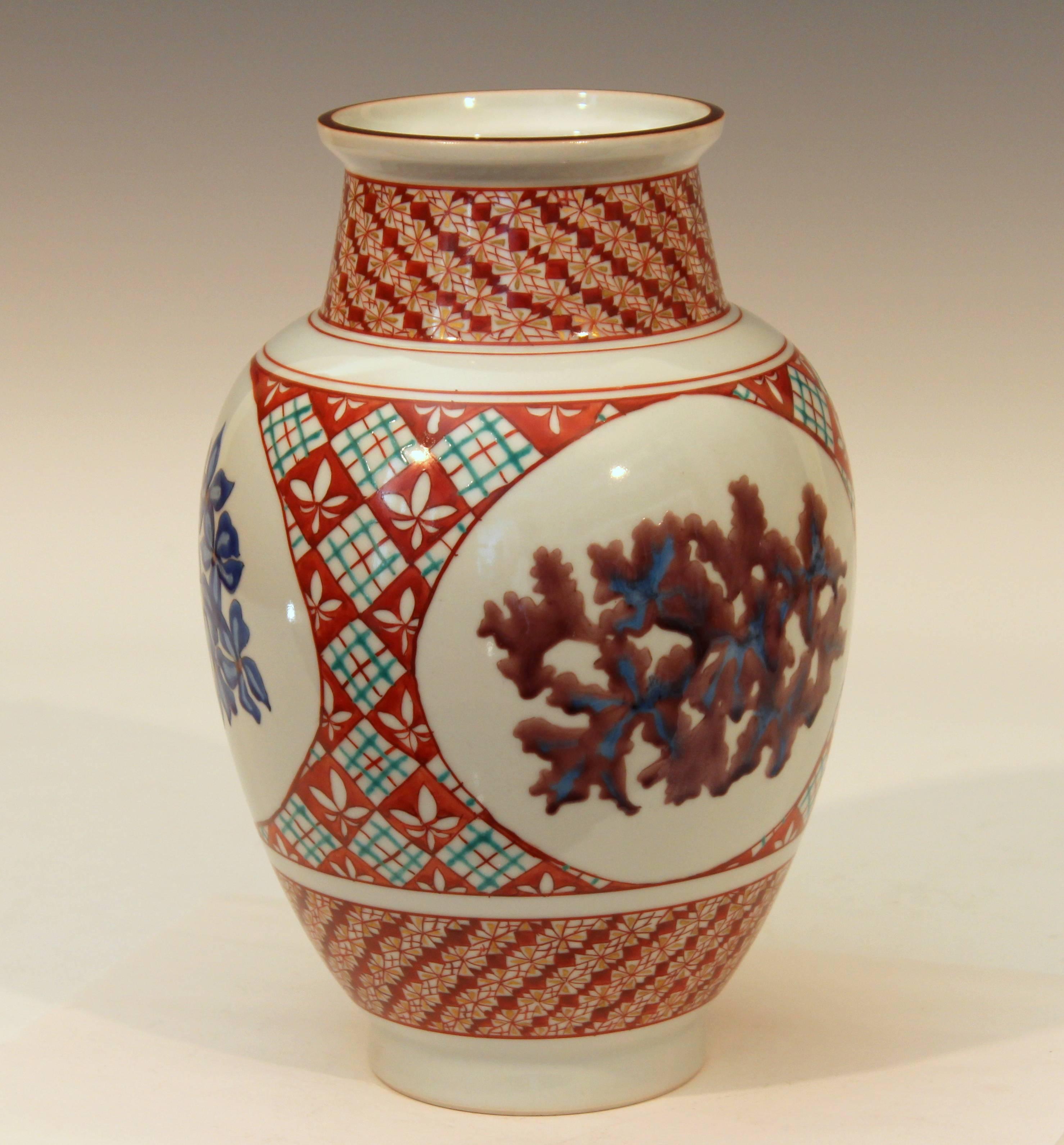 Kutani studio porcelain vase with three reserves of colored blossoms against a background of elaborate geometric designs, circa late 20th century. 9 5/8