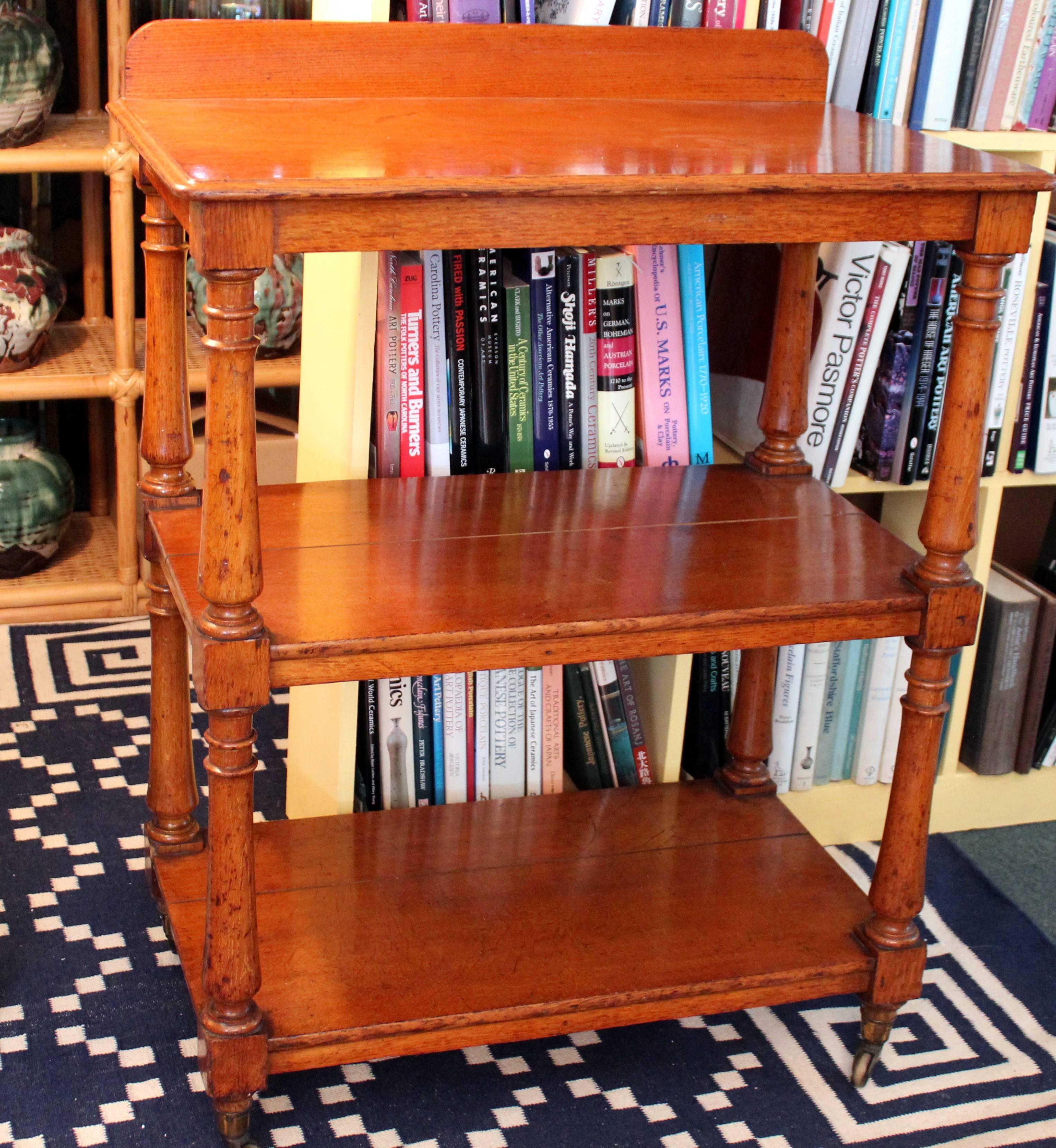 Antique English oak three shelf tea trolley cart on brass castors, circa late 19th century. Measures: 36 1/2