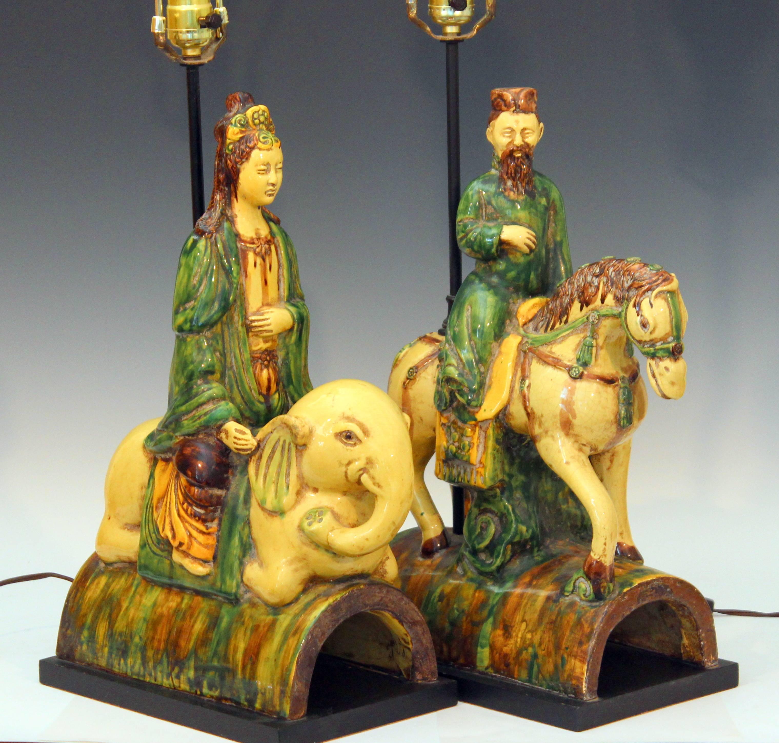 Pair of Italian Zaccagnini pottery lamps modeled after Chinese Ming Dynasty roof tiles in the form of Bodhisattvas mounted on elephant and horseback and decorated in three color sancai glaze, circa 1950s-1960s. Fun and spiritual! 30" high