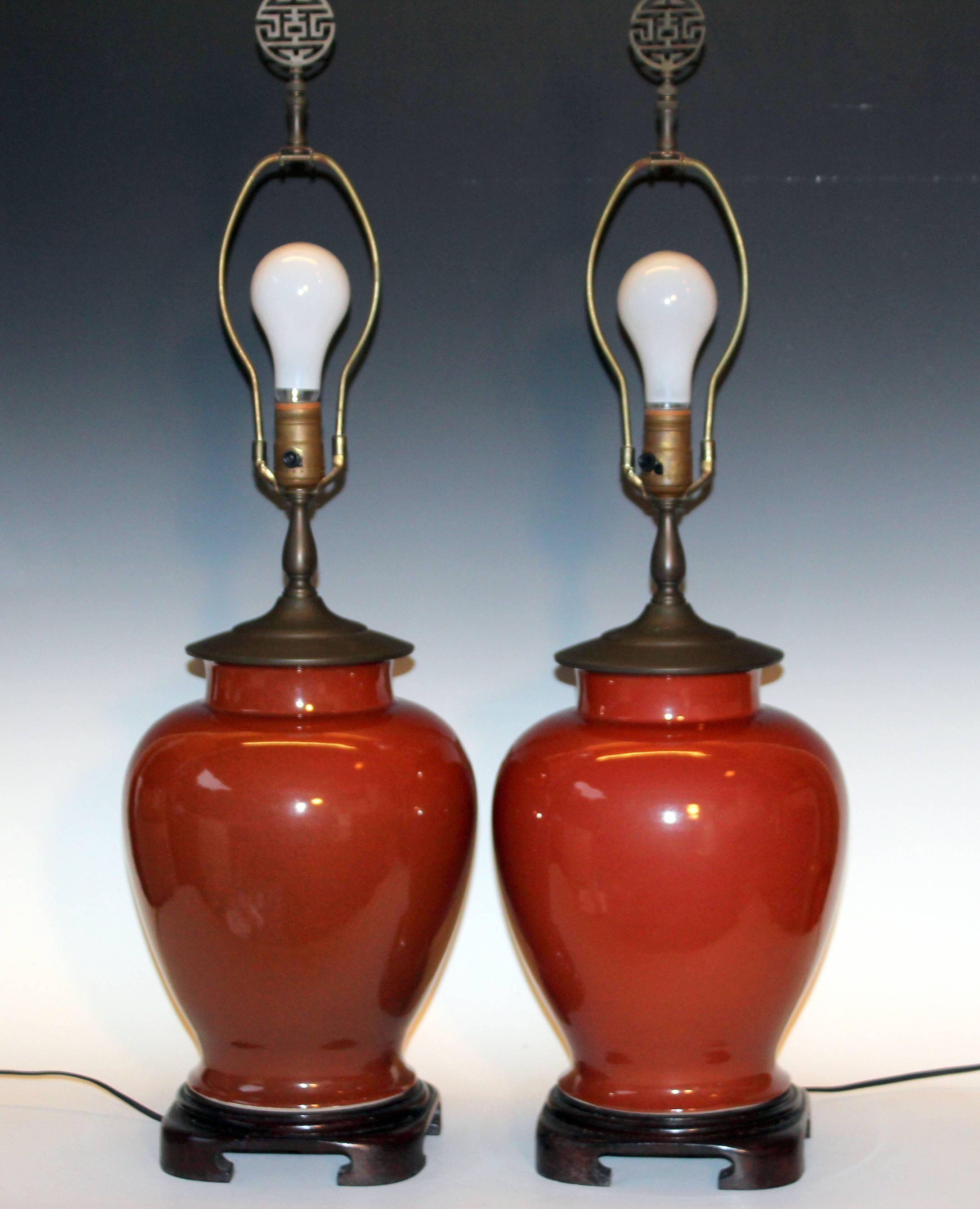 Pair of vintage Chinese porcelain lamps in iron rust glaze and good quality brass hardware with mellowed patina, circa 1970s. Chinese character brass finials. 32