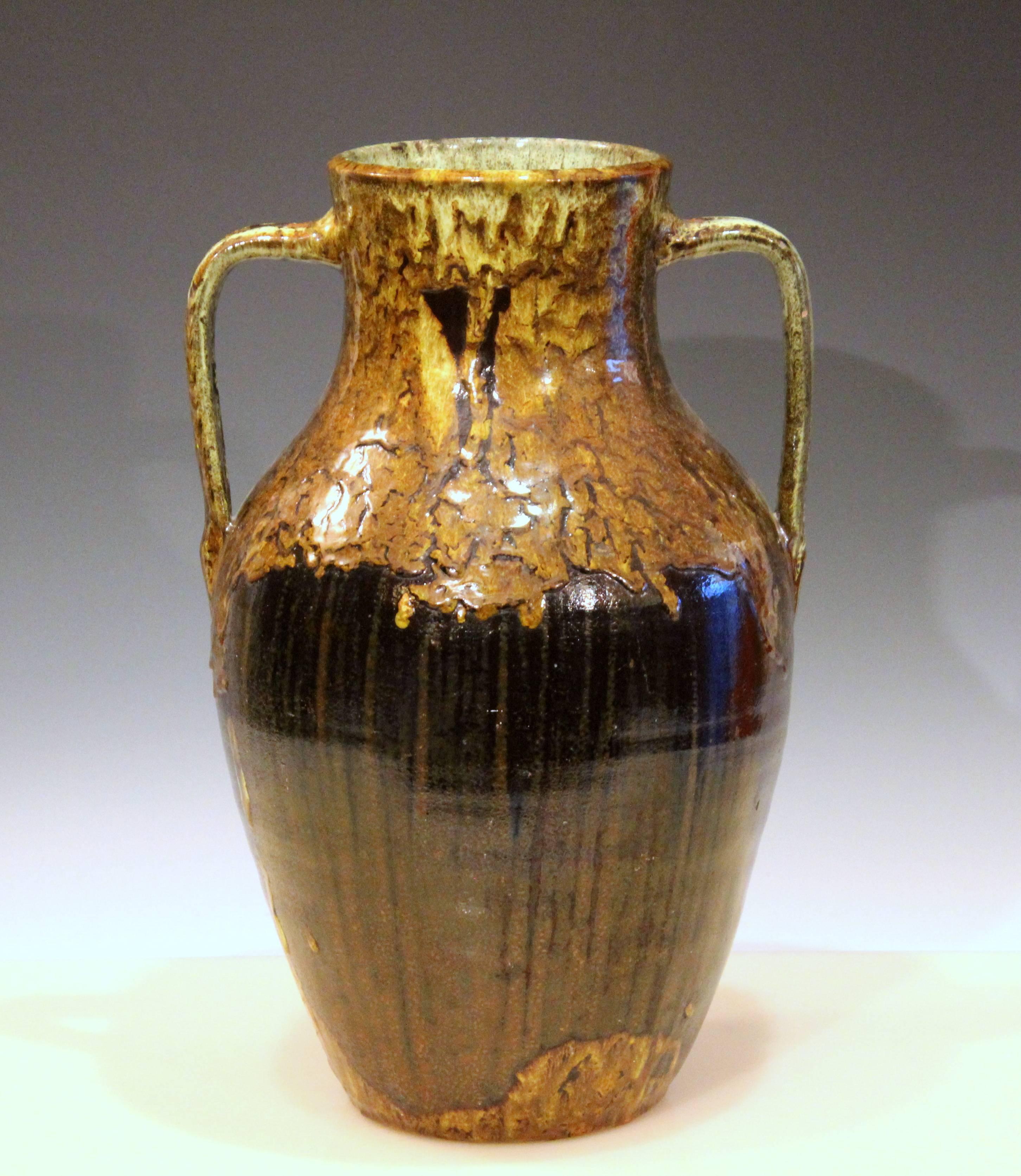 Vintage North Carolina vase in traditional form with pair of squared off handles from the JB Cole pottery, circa early 20th century. With tactile double dipped glaze and flashes of different colors. Measures: 16" high, 10 1/2" across