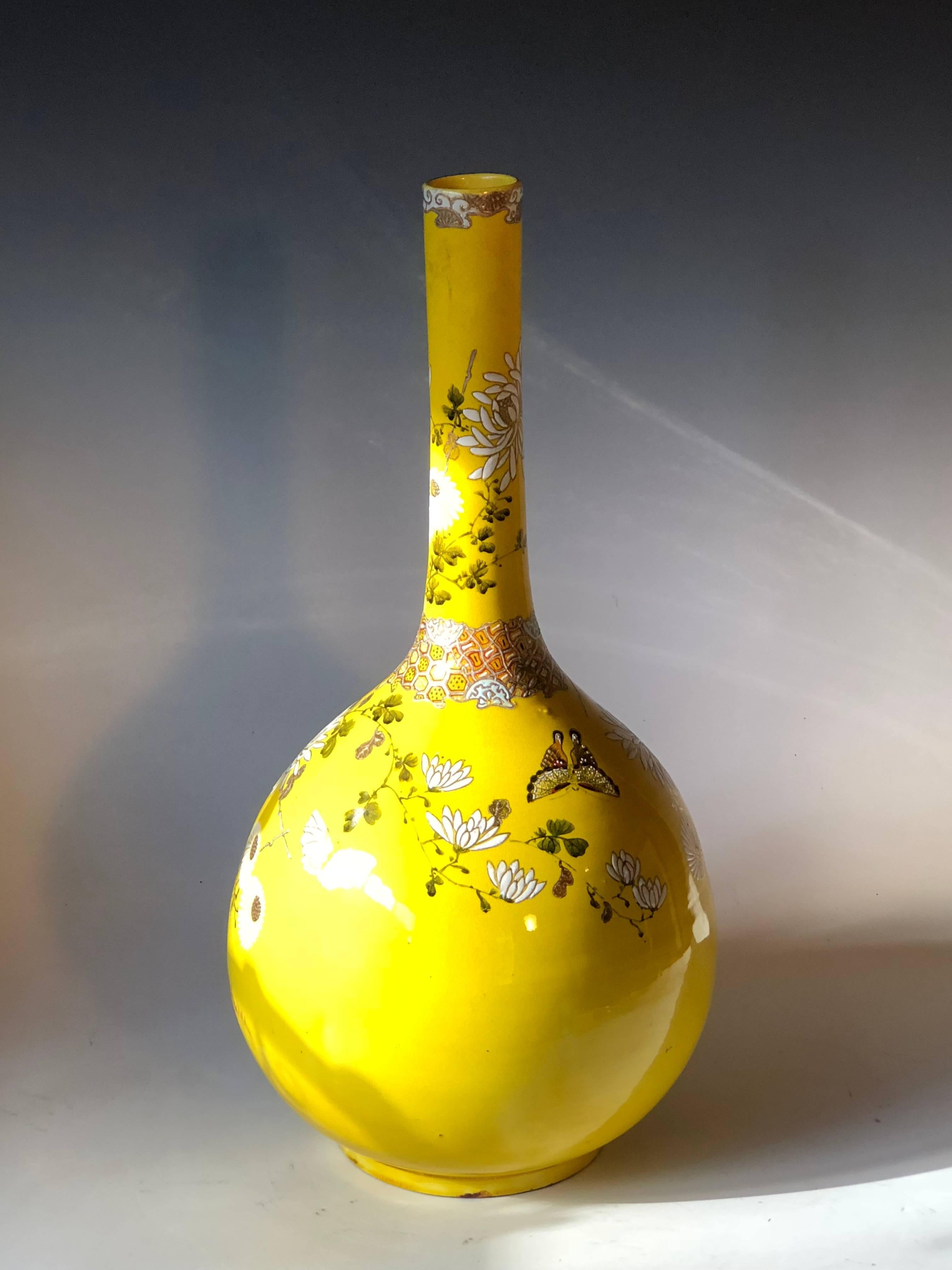 Antique Satsuma bottle vase decorated with enameled chrysanthemums, peonies, and butterflies on an electric yellow crackle glaze ground. From the city of Kyoto, circa 1910. Measures: 18