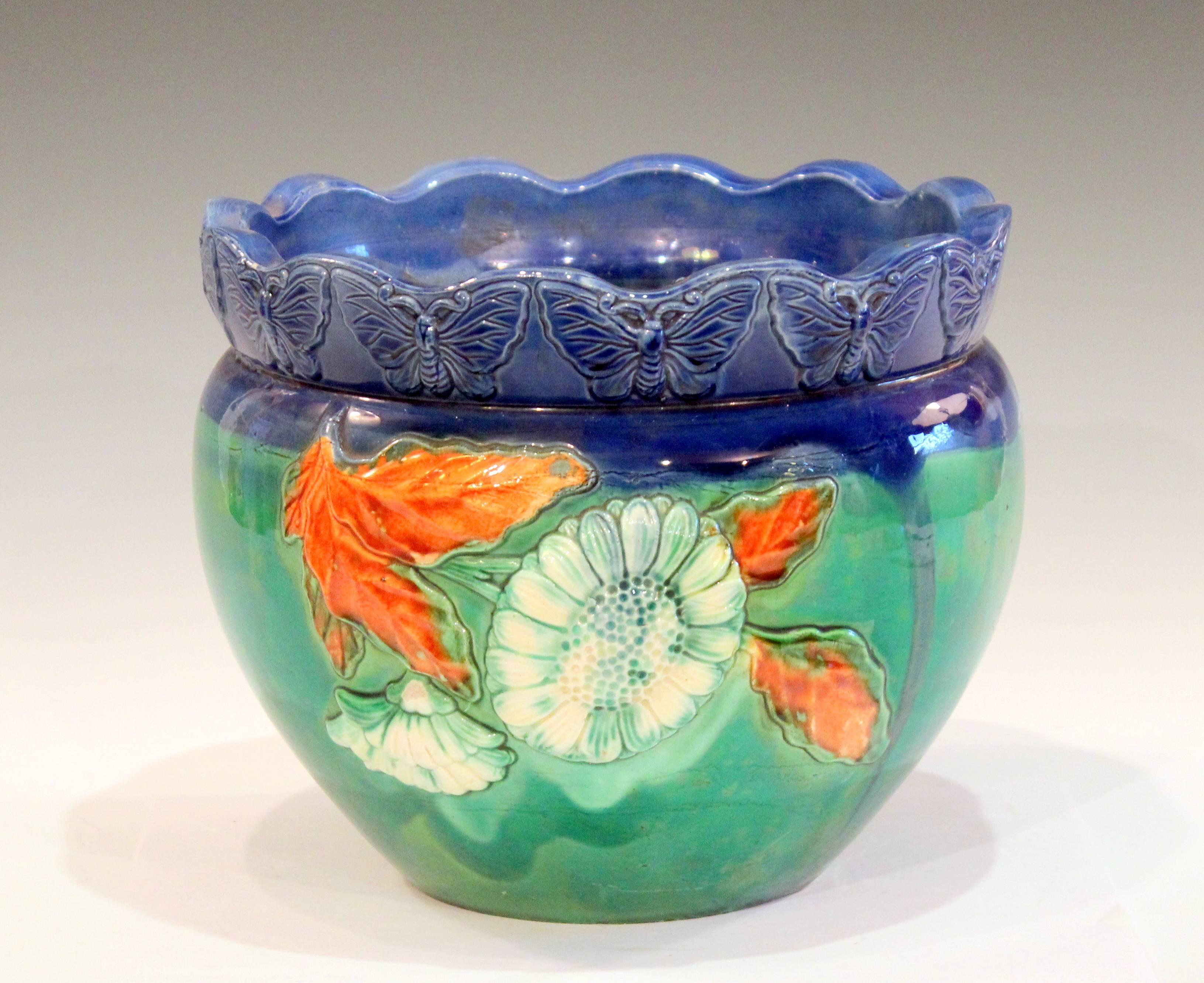 Vintage, handmade Awaji Pottery jardiniere with applied decoration of blooming flowers and a band of butterflies at the rim, circa 1930. Glazed in vibrant green, blue, and orange. Impressed marks. 7