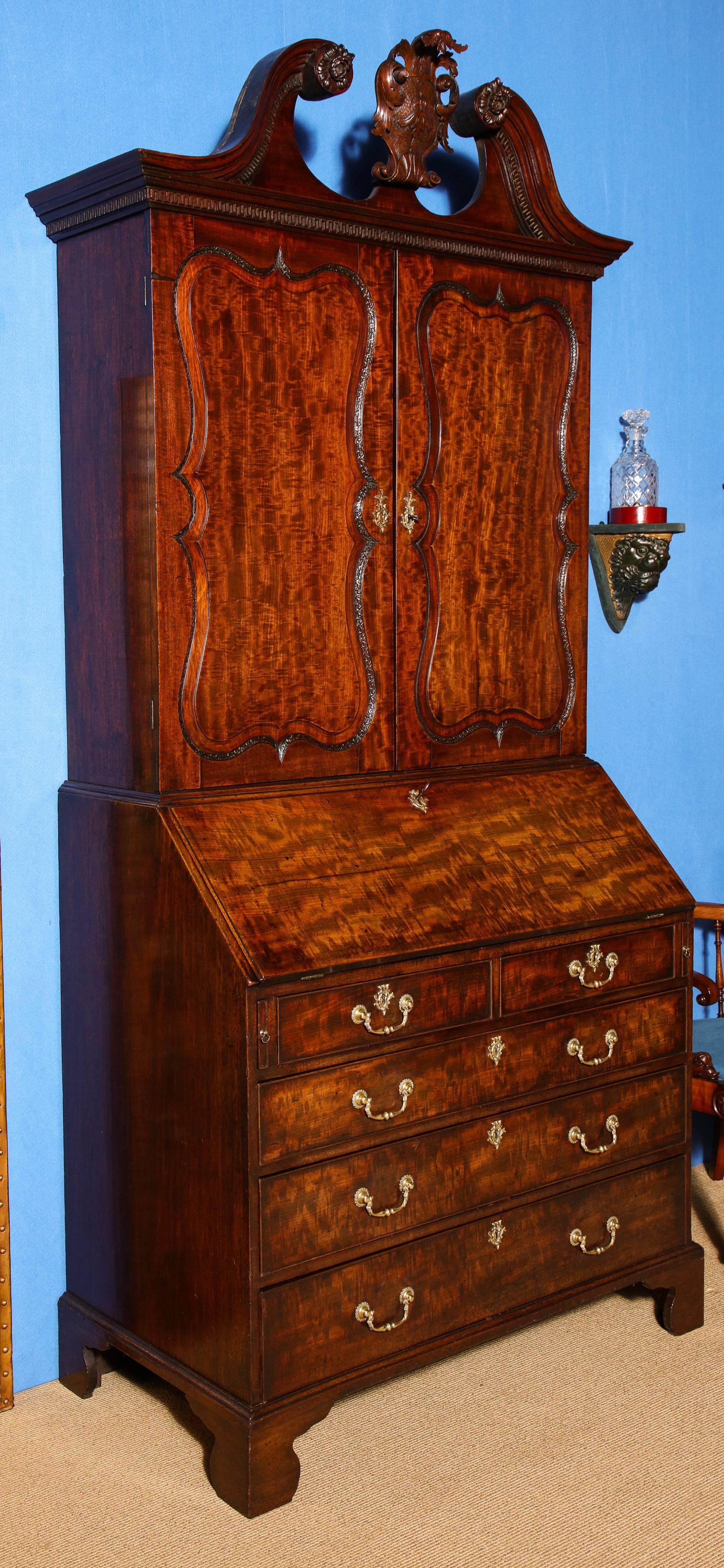 George II mahogany Bureau bookcase attributed to Giles Grendey (London 1693-1780), the upper section with dentil molded swan's neck pediment with flowerhead terminals and centering a foliate and shell carved punchwork cartouche, the molded cornice