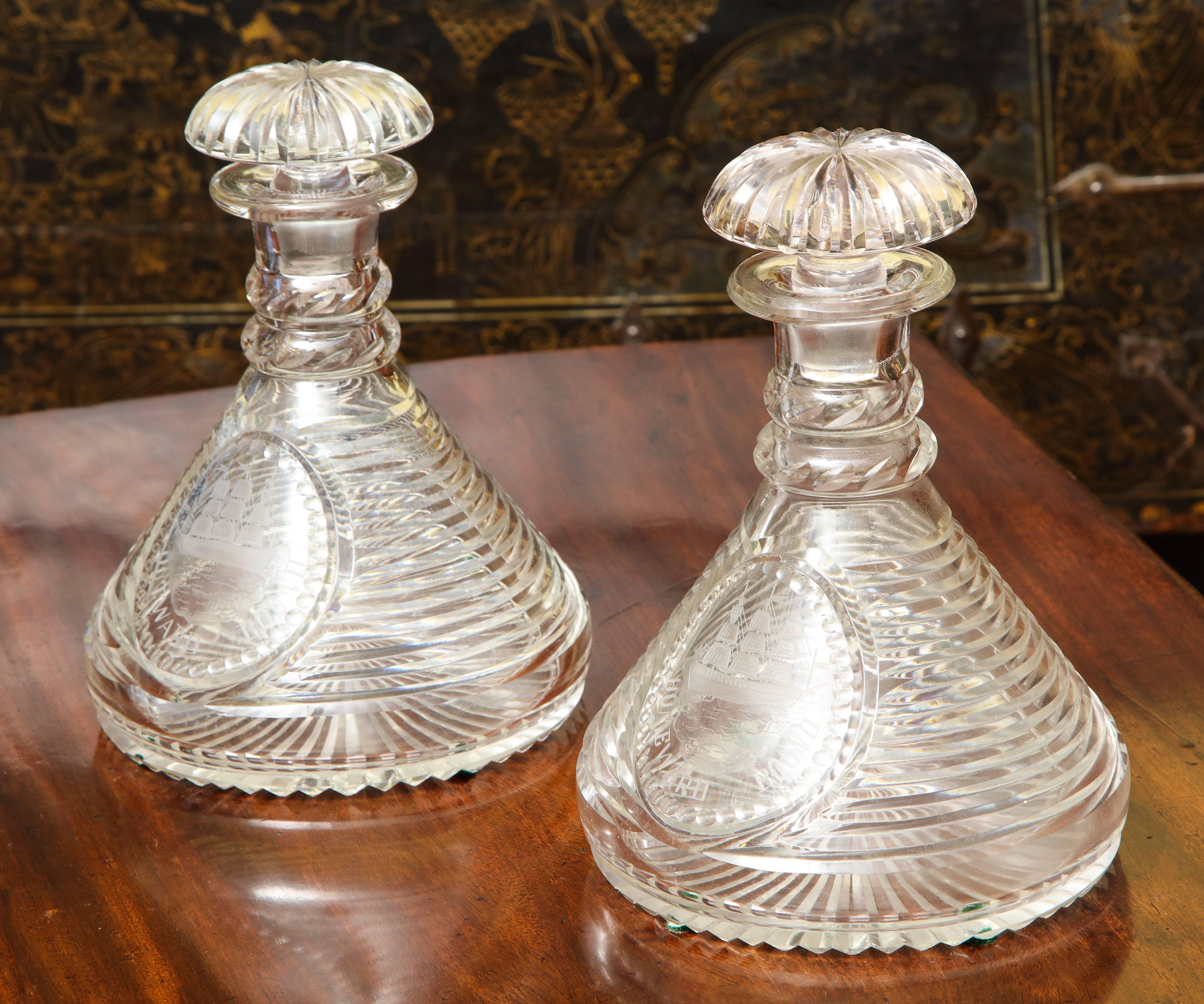 Fine pair of cut crystal ship's decanters, each with a smooth flared top above diagonally cut double neck rings, the bodies of stepped form with star cut bases and engraved in a central oval field with a three-masted schooner at sea below which is