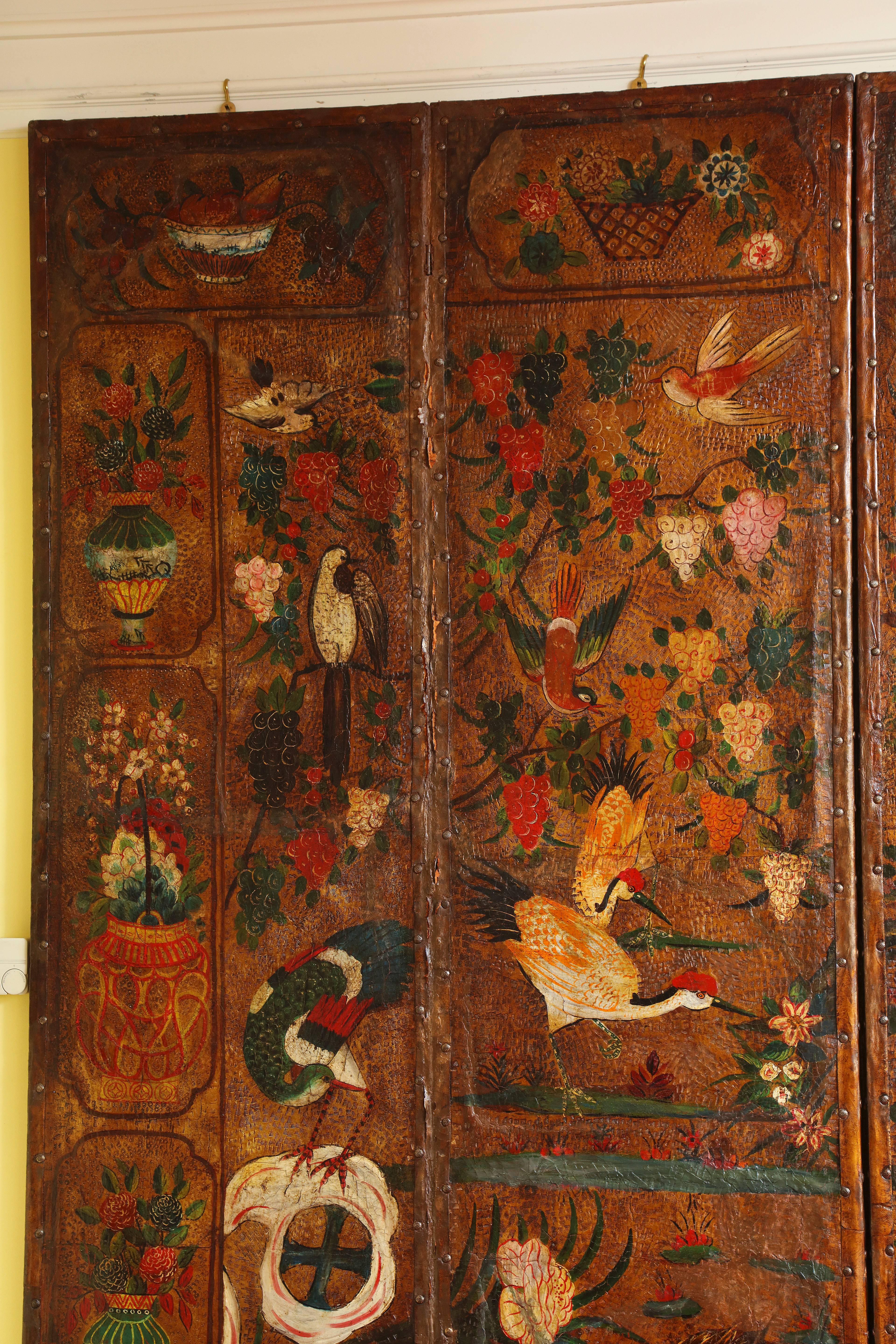 Very Fine English Six Panel Chinoiserie Decorated and Gilt Tooled Leather Screen, the center painted in vibrant original colors with birds and flowering branches with a border of symbolic antiques, all in imitation of a 17th century Chinese