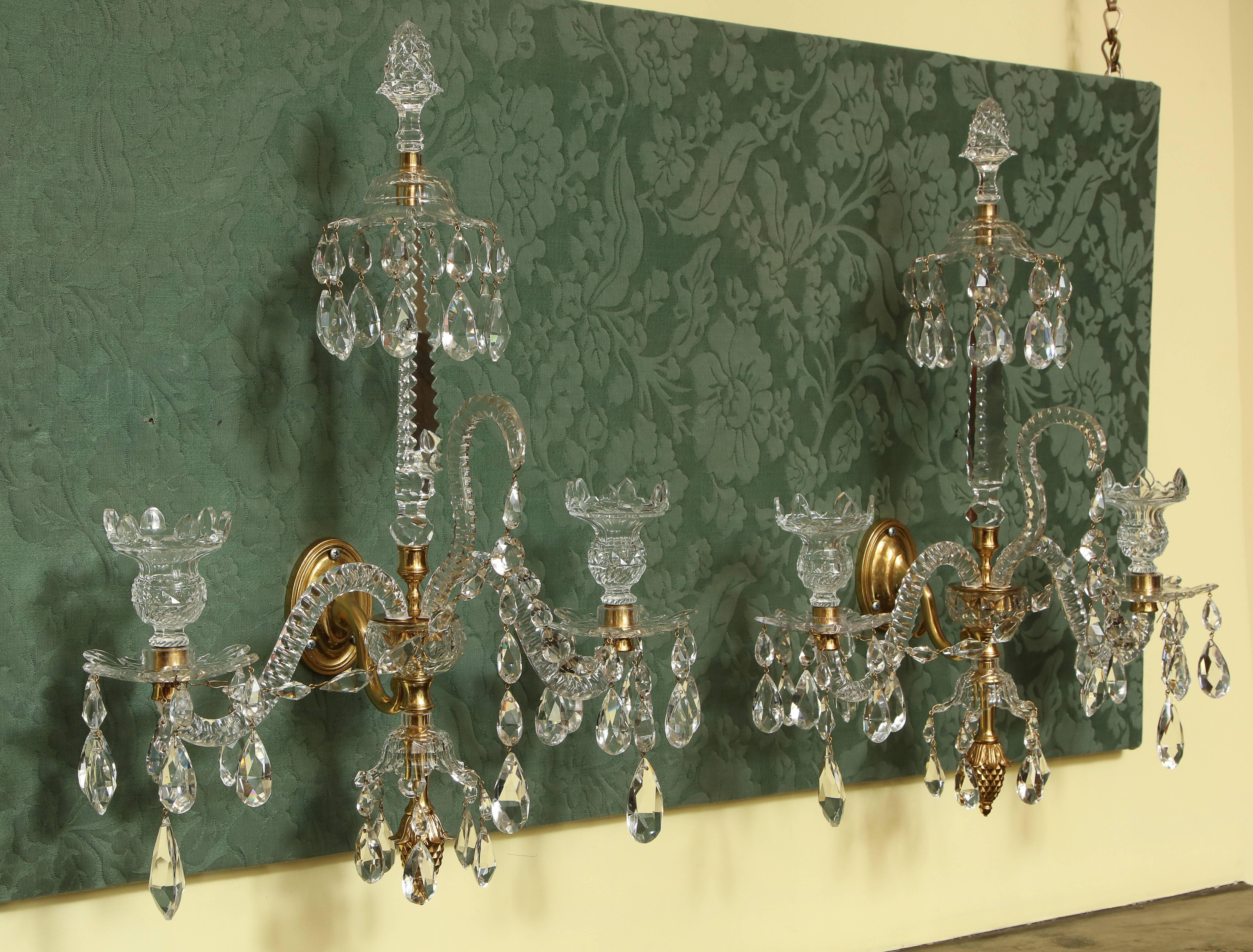 Very fFne Pair of Adam Period Cut Crystal and Ormolu Two Light Wall Sconces, having a crystal pineapple top finial with a cut canopy with drops on a triangular notched spire, the two faceted serpentine arms with notched cups and bobeches, festooned