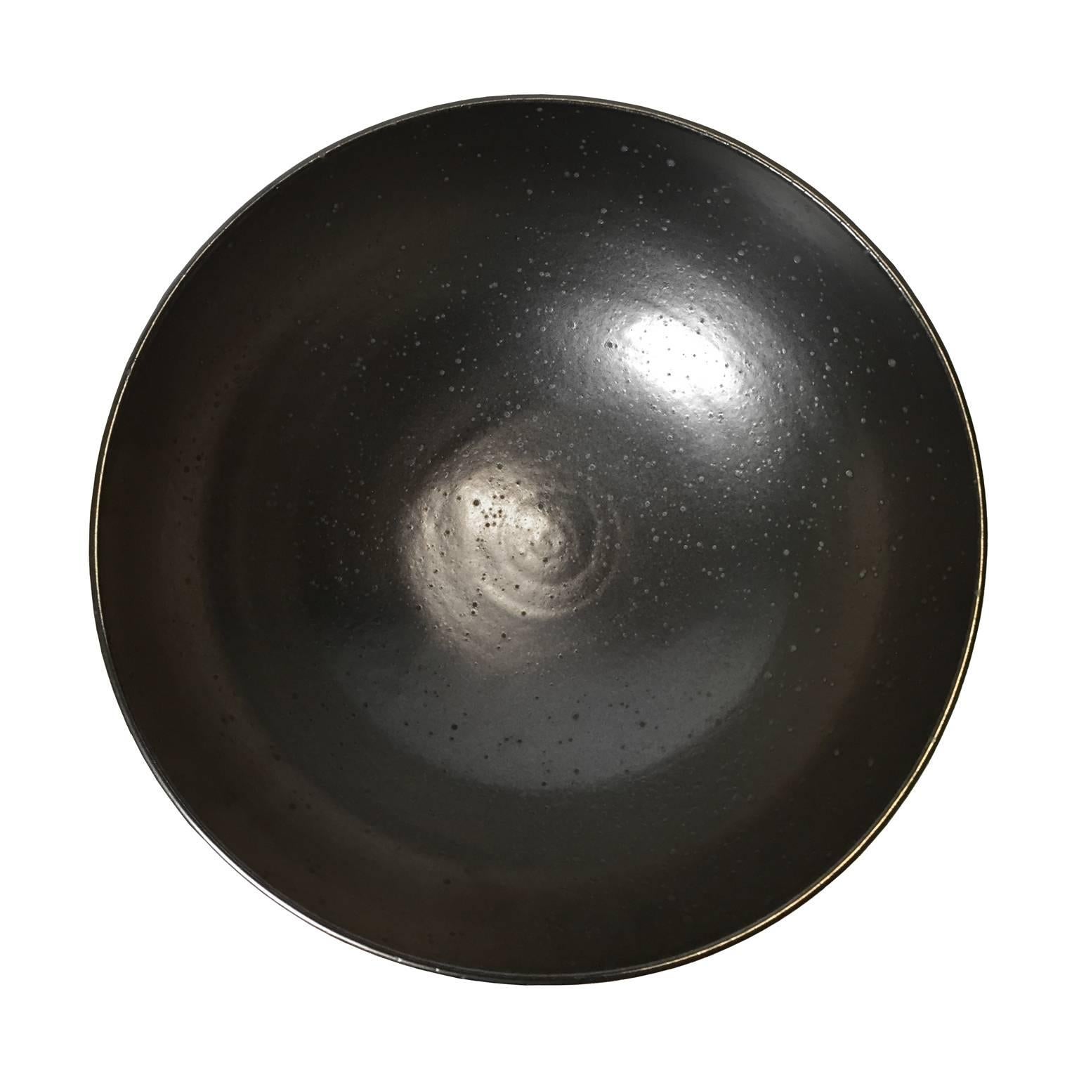 Black moonscape glaze large ceramic bowl by Sandi Fellman, USA, 2017. 

Veteran photographer Sandi Fellman's ceramic vessels are an exploration of a new medium. The forms, palettes, and sensuality of her photos can be found within each piece. The