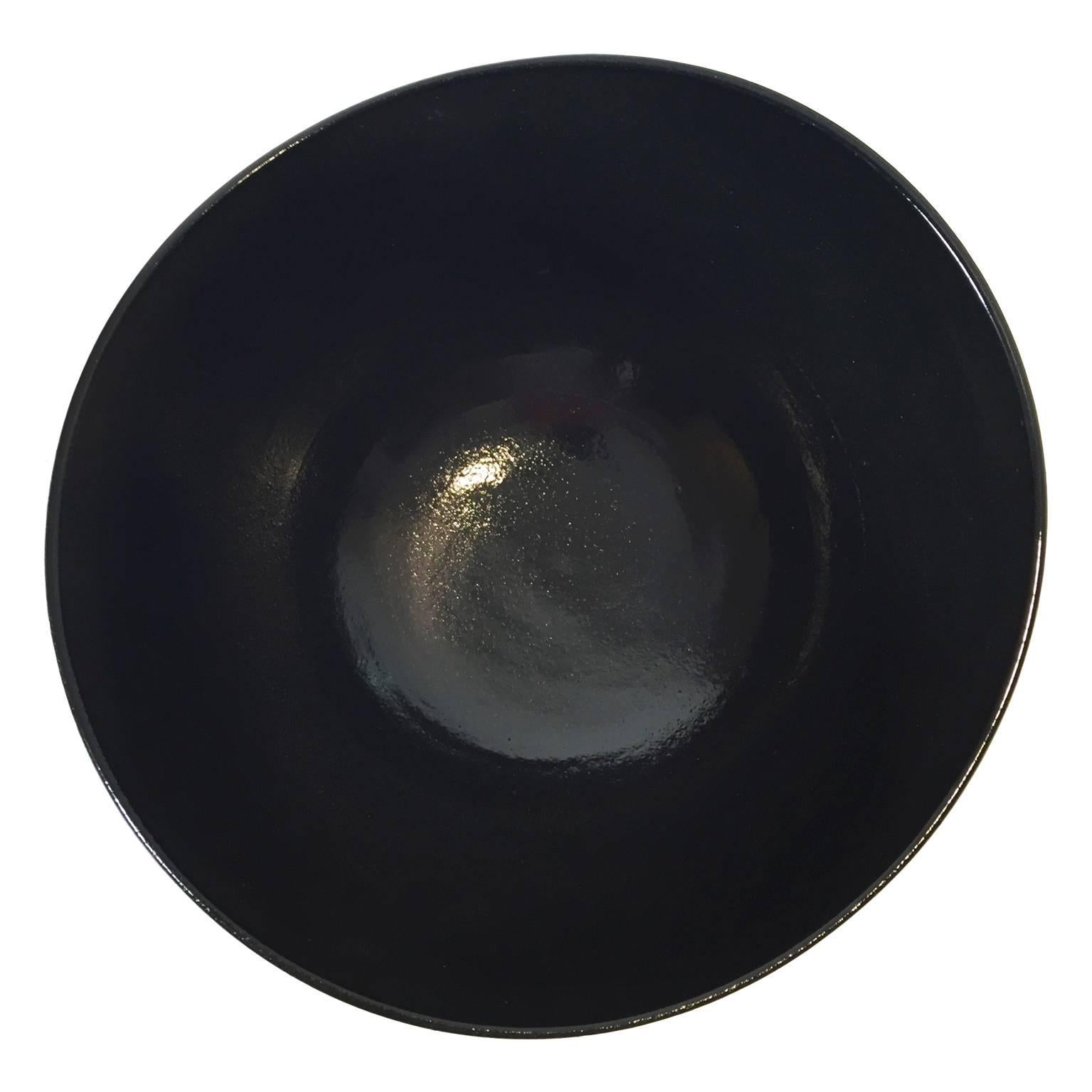 Asymmetrical ceramic curved bowl with matte black ombre glaze exterior and black gloss interior by Sandi Fellman, 2016. 

Veteran photographer Sandi Fellman's ceramic vessels are an exploration of a new medium. The forms, palettes, and sensuality