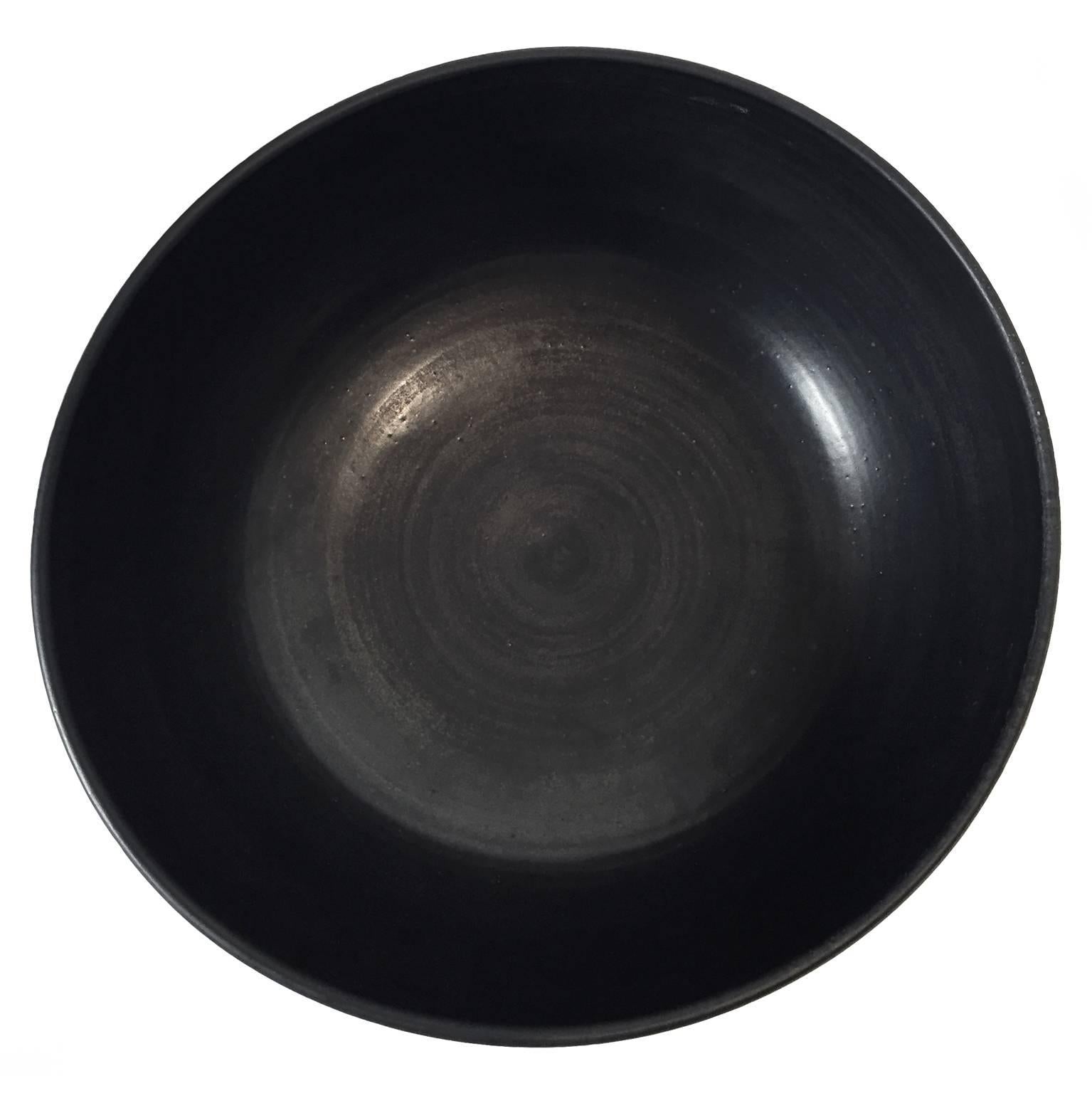 Curved ceramic bowl with black wax glaze exterior and black sheen glaze interior by Sandi Fellman, 2016.

Veteran photographer Sandi Fellman's ceramic vessels are an exploration of a new medium. The forms, palettes, and sensuality of her photos