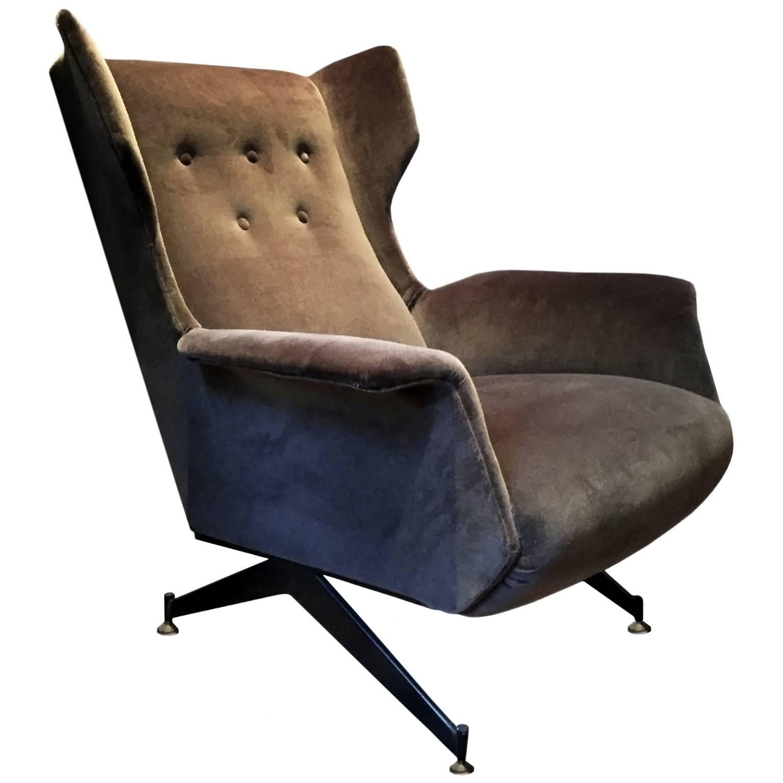 Vintage brown velvet upholstered wingback chair with black metal legs.