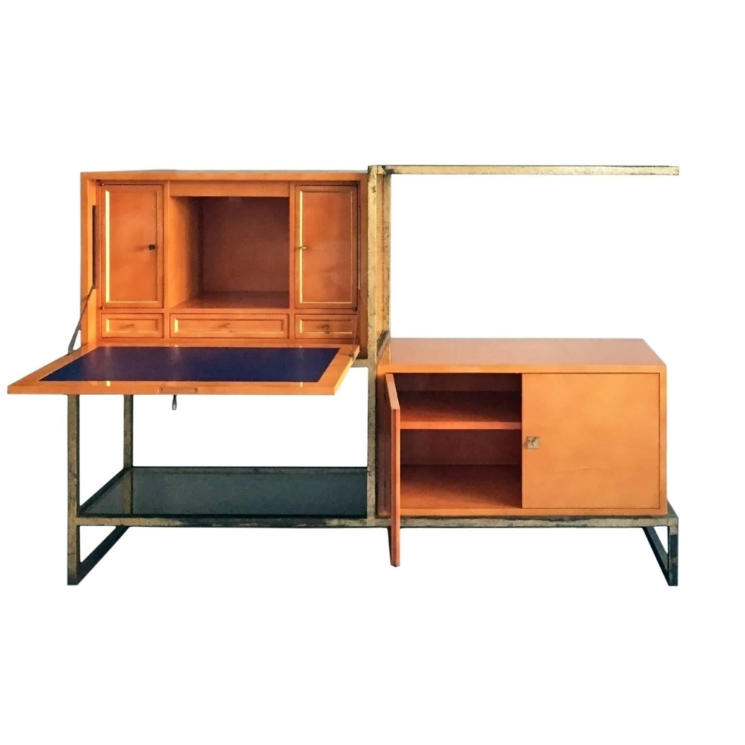 Exceptional lacquer and gilt iron secretary cabinet by Roger and Robert Thibier.

Executed in the 1960's as a custom commission, this exceptional piece features two orange lacquered cabinets housed in a gilt iron metal structure with two glass