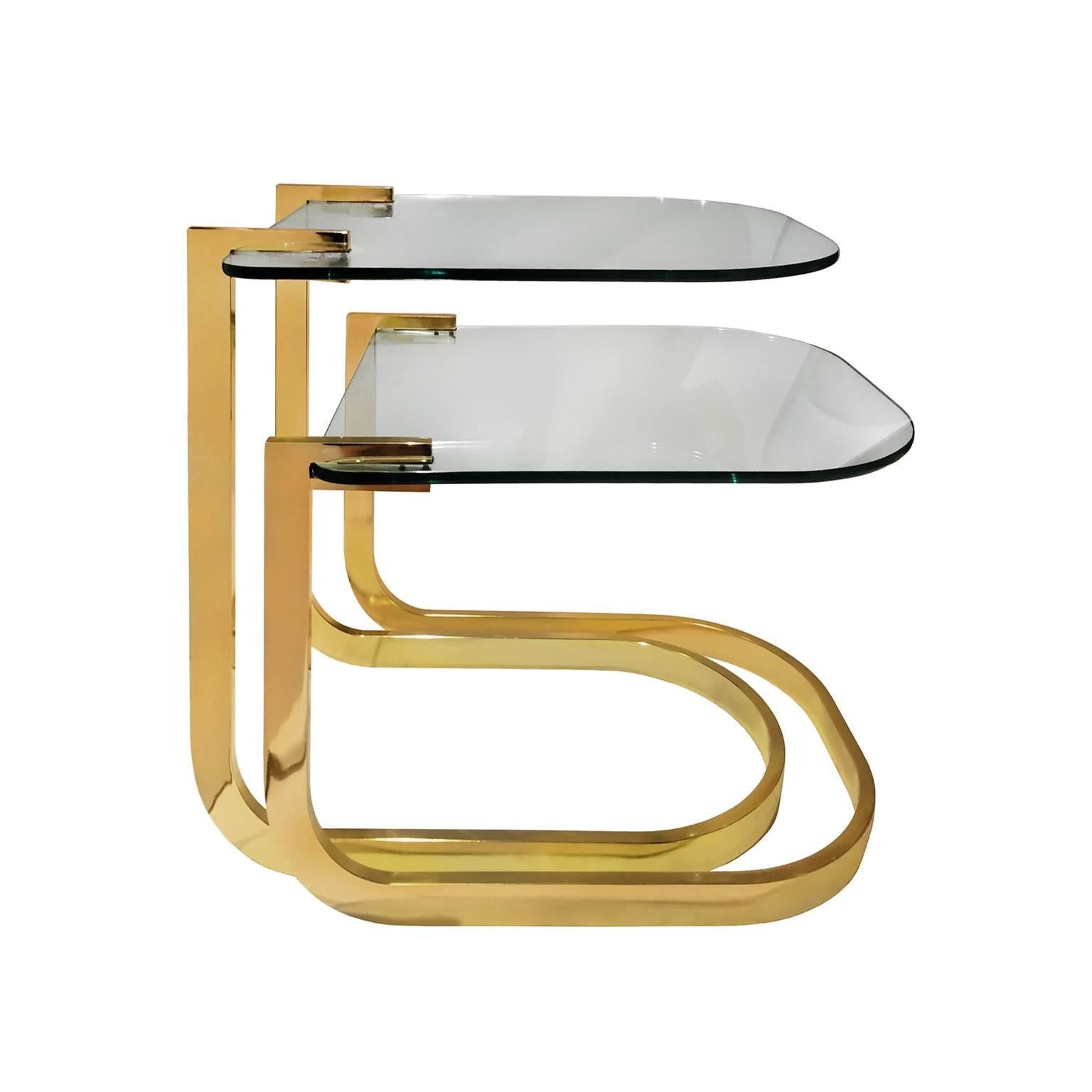 Set of two curved brass and glass nesting side tables, USA, 1970s.