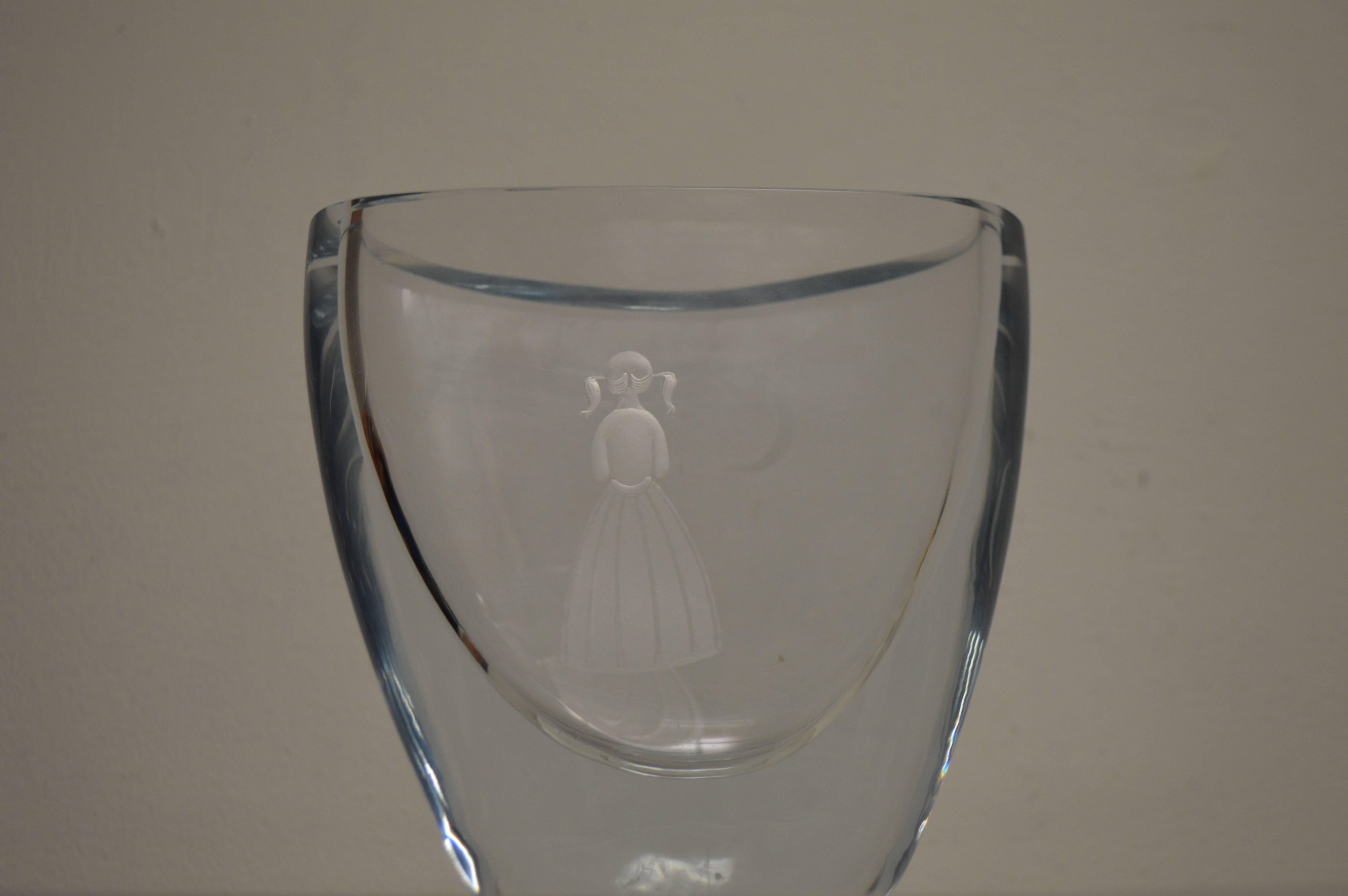 Offered is a midcentury Swedish modernist art glass vase made by Strombergshyttan. The vase has a etched back view of a girl looking at a crescent moon and stars that are etched into the other side of the vase.

It is signed on the bottom  with