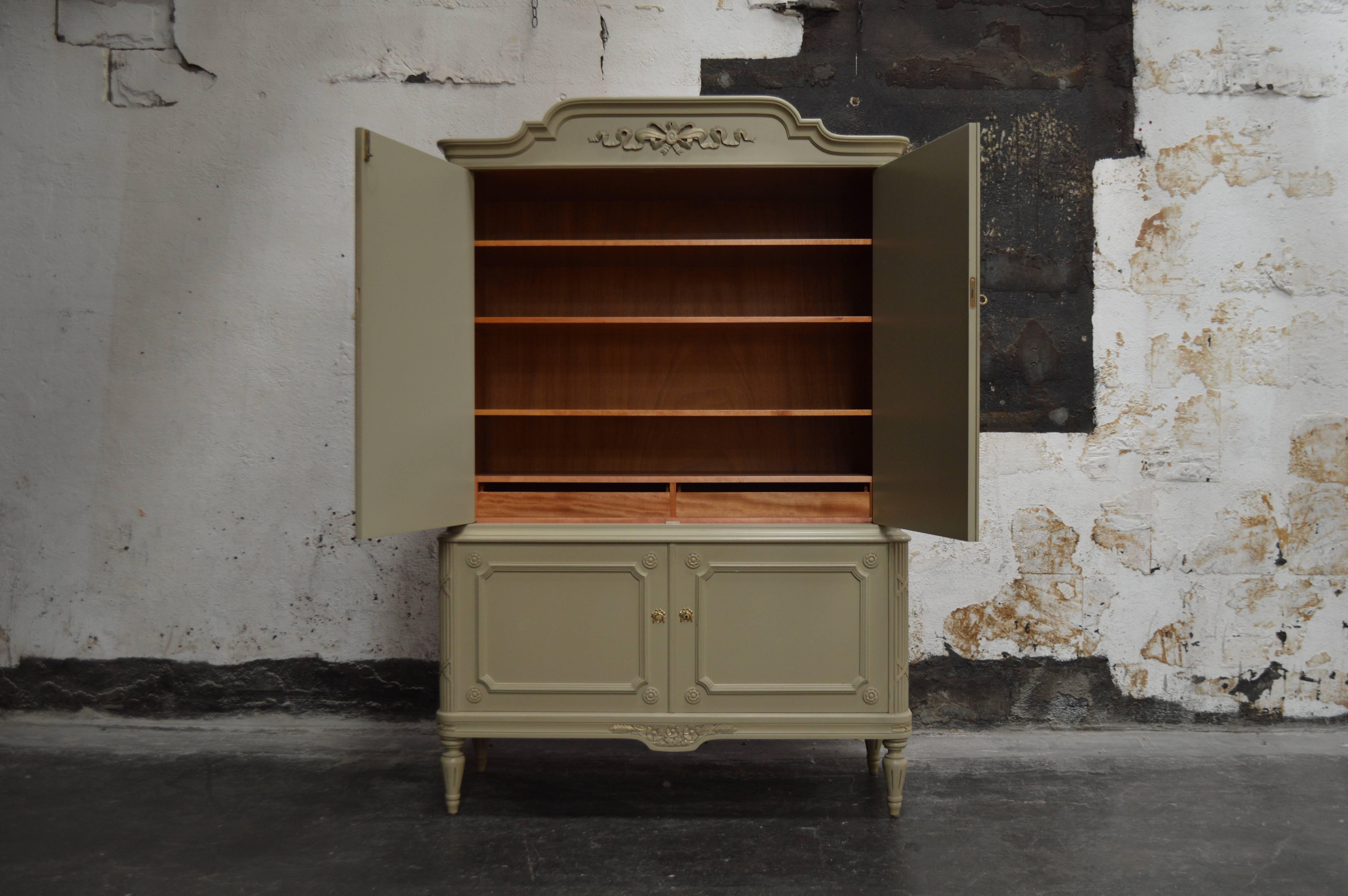 Gustavian Style grayish-greenish off-white painted storage cabinet. Adjustable shelves. Has contrasting unpainted wood interior with adjustable shelves and two small drawers on the top. This piece could be used in a bedroom, dining area or even in a