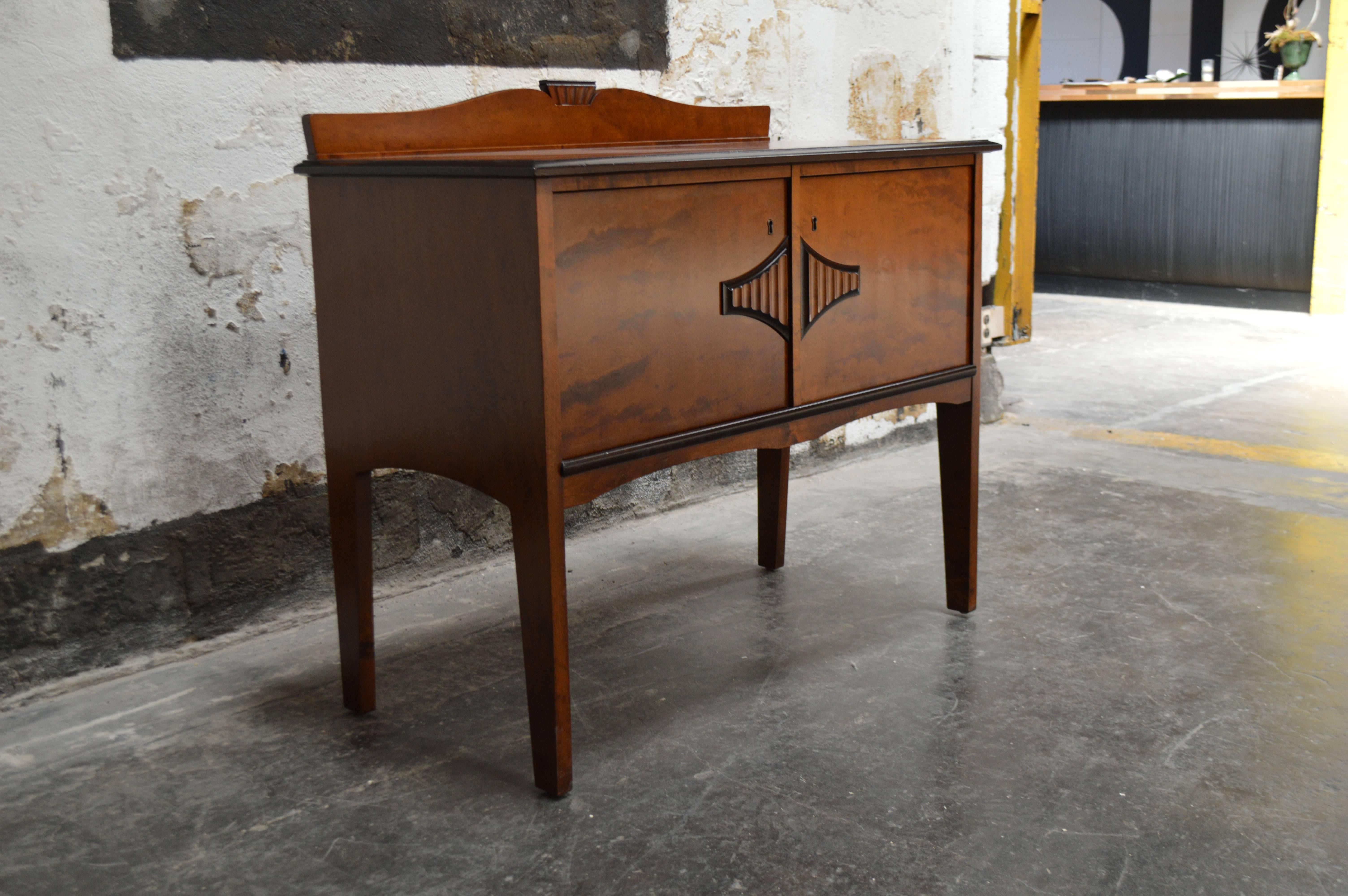 Gorgeous Swedish neoclassical buffet, sideboard or server with dark golden birch with ebonized trim. Two doors open to reveal shelving. Beautifully detailed with carvings on the doors and gracefully curved detailed back-splash. Note: larger matching