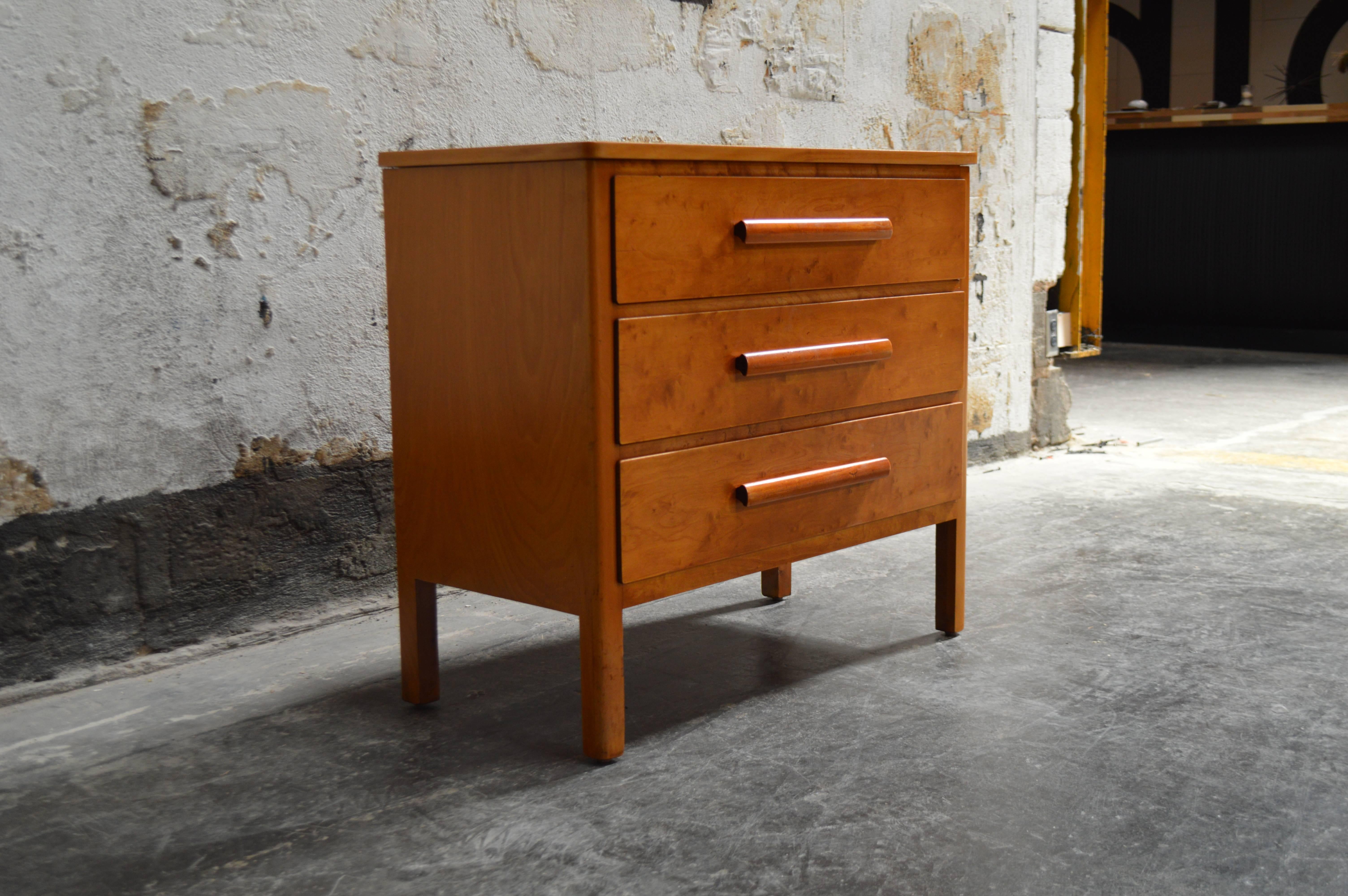 Swedish three-drawer chest of golden elm with rounded center pulls atop sleek built in legs. Great versatile storage piece and also makes for a great nightstand.