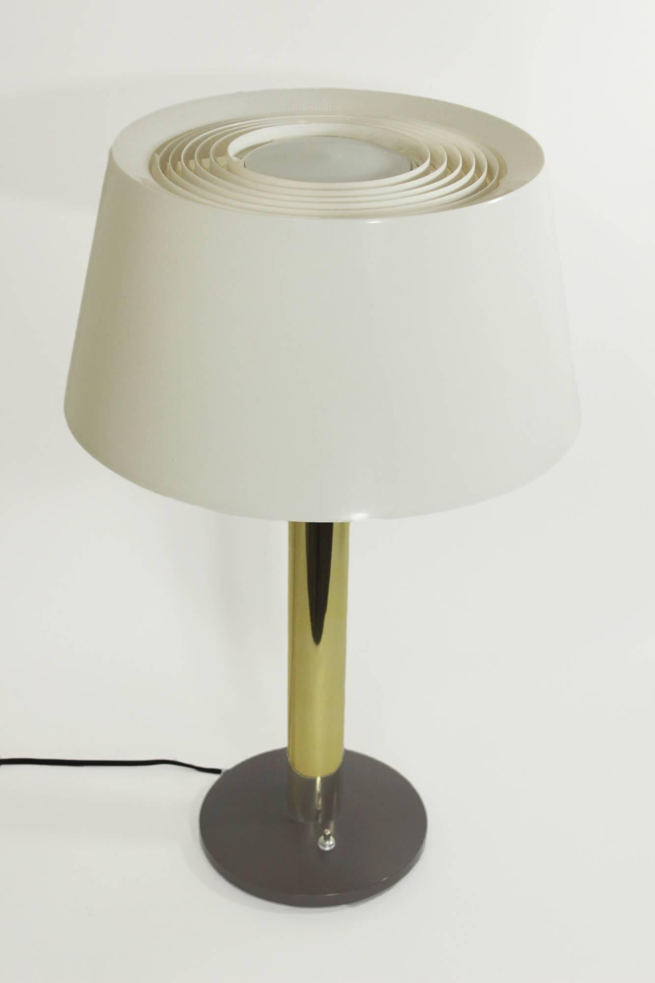 Clean modern lines and minimal detail are the hallmarks of this Mid-Century table lamp designed by Gerald Thurston for Lightolier. Two pieces are available for sale. The lamp features the patented Lightolier vented plastic shade with a bobesche