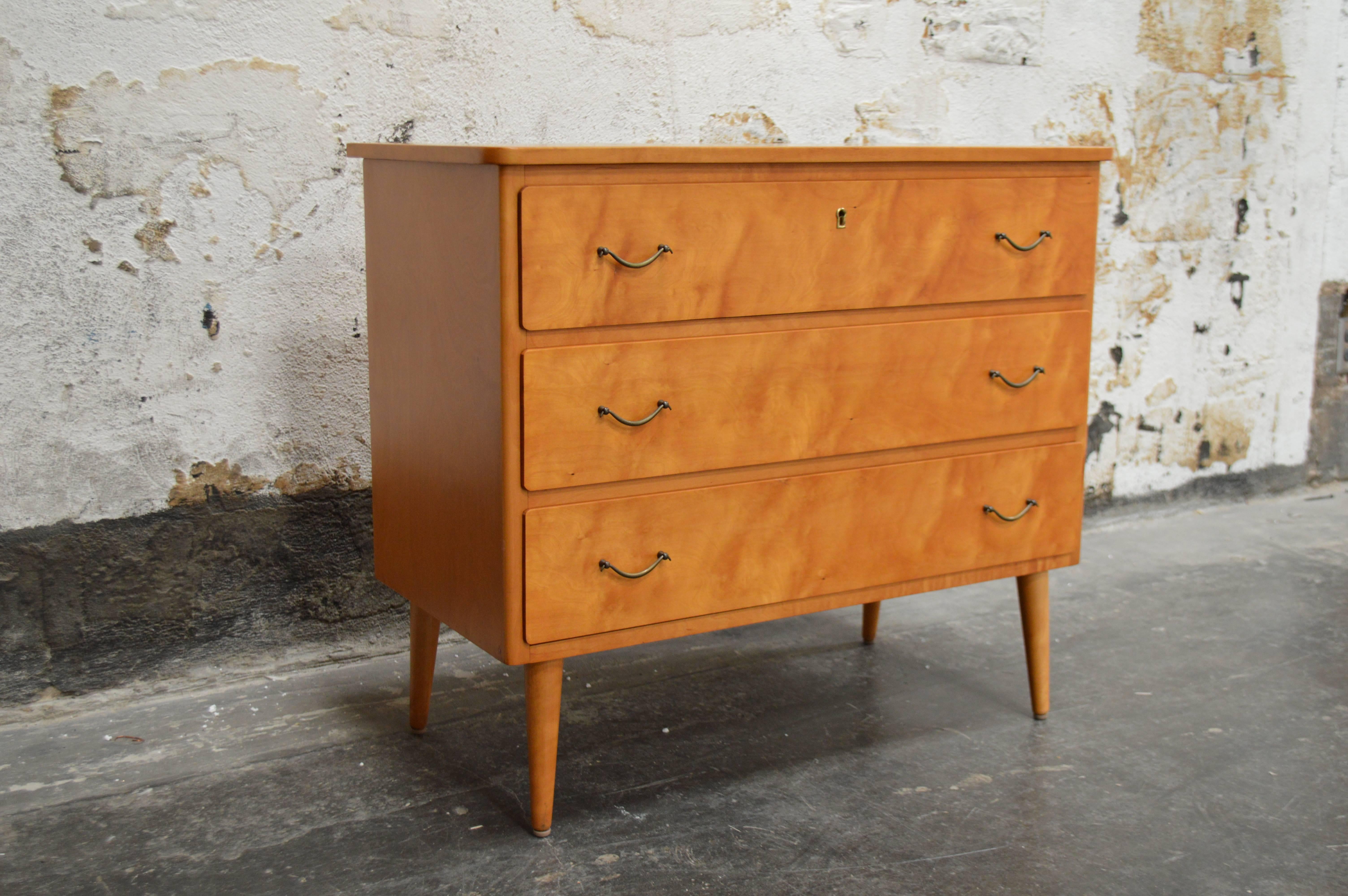 Three-drawer golden elm chest on round tapered legs with original brass hardware. A great piece to store your bedding or clothes. A handsome piece of furniture in any room.

Note - We do have a few other similar pieces that would make a great pair