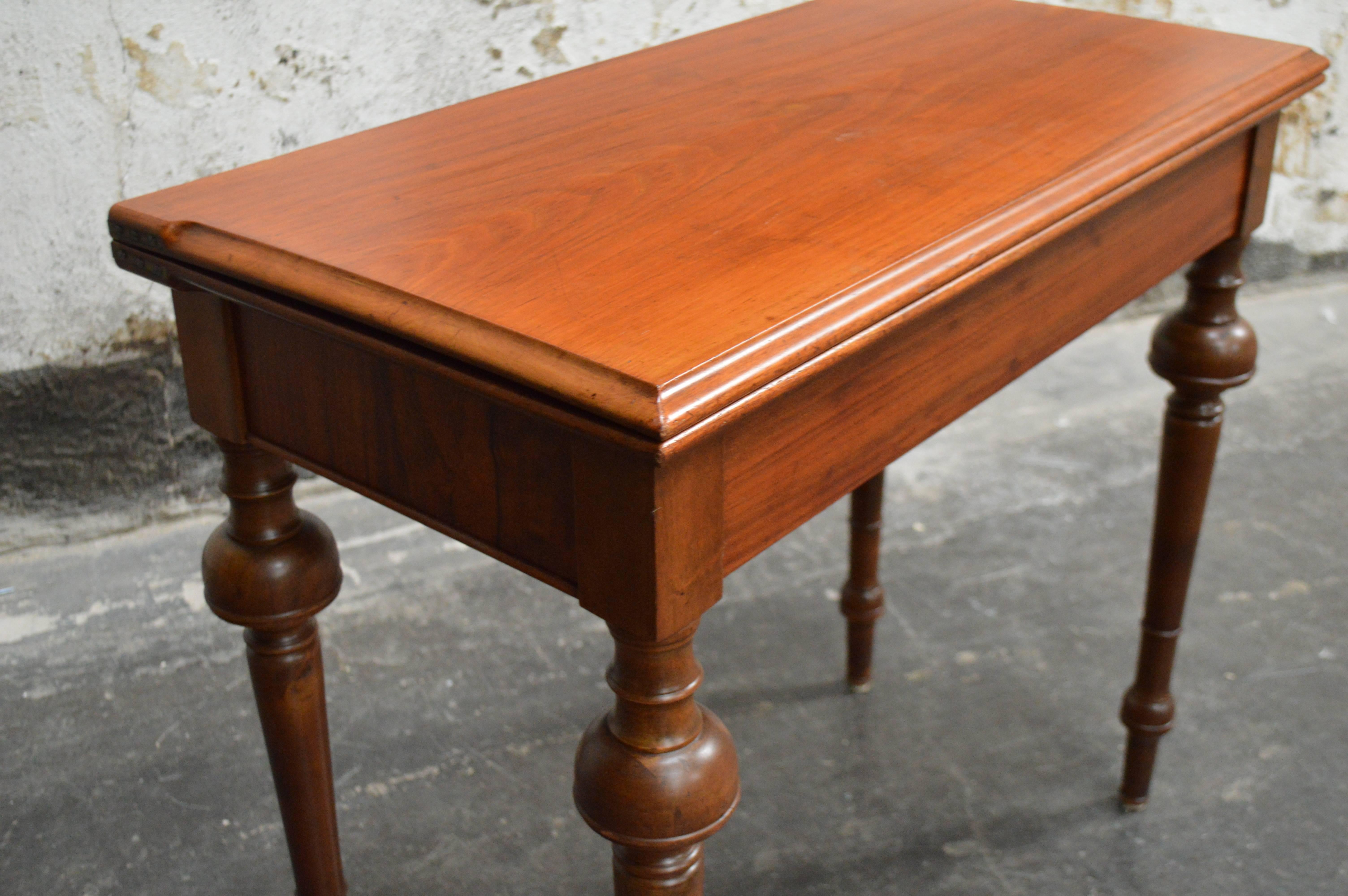 Swedish neoclassical mahogany console table that flips open to become a card table. If you take the top completely off it is a backgammon game inside. Interesting legs, clean and handsome design. 

When the tabletop is folded it is 17.5