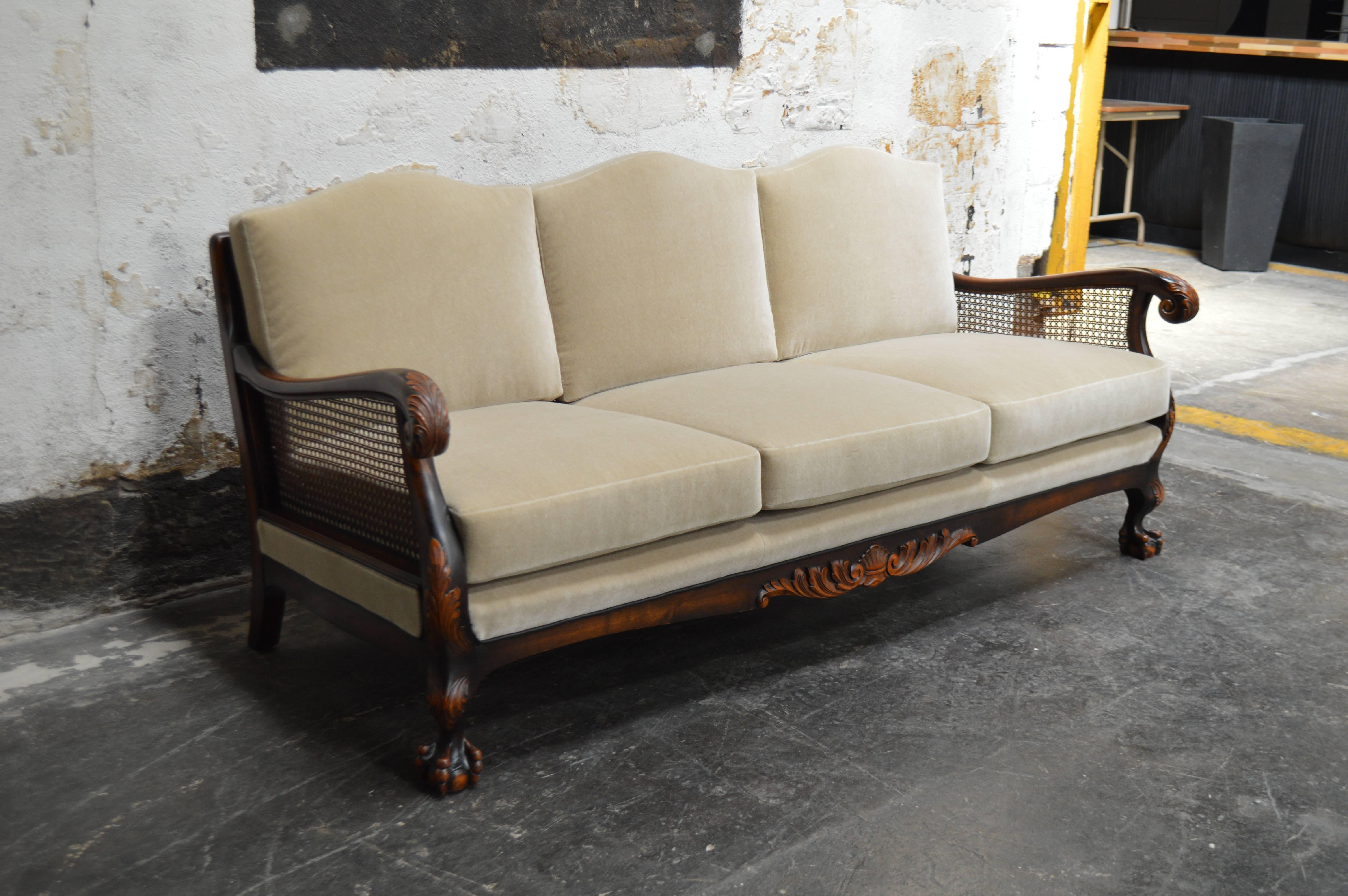 Dark flame birch carved sofa newly upholstered in beige mohair. Features caned back and arms and exposed carved wood that has a handsomely aged patina. Cushions have eight-way hand-tied springs and new recycled foam.

Fabric swatch available upon