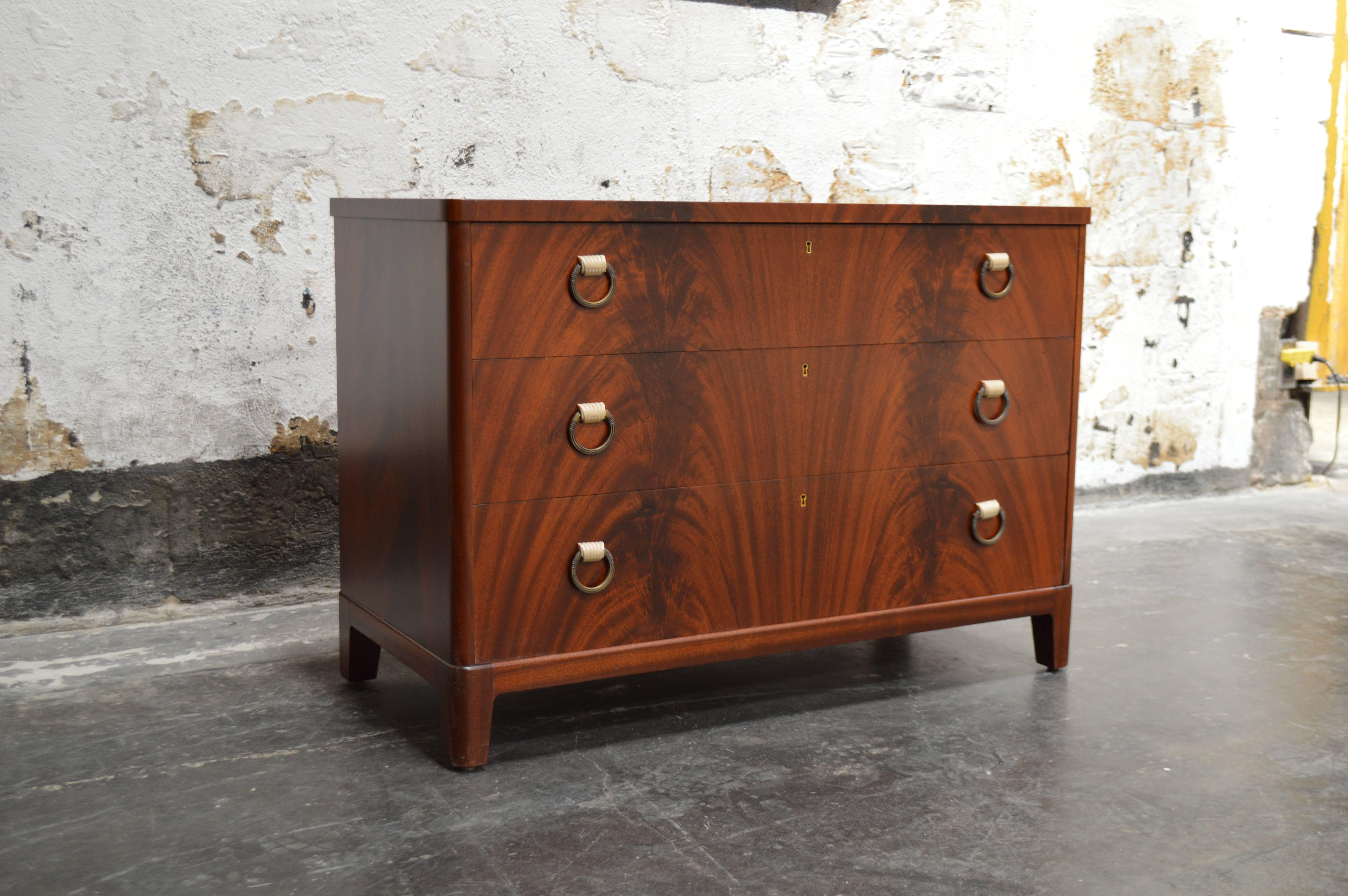 Swedish Art Deco chest fitted with three spacious drawers in beautiful bookmatched mahogany with. This chest has nickel pulls with ivory color bakelite details. Perfectly scaled for just about anywhere in the home.