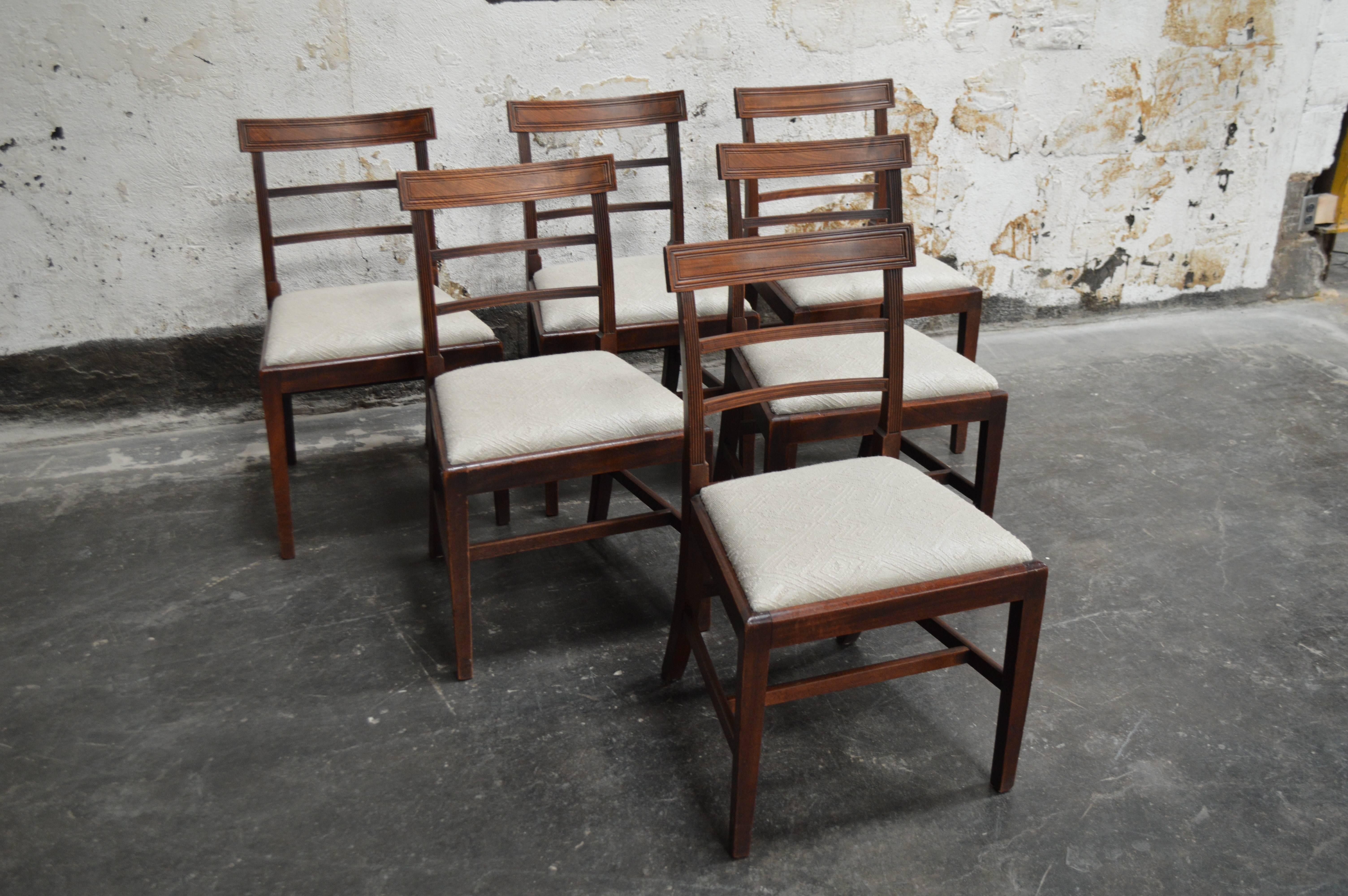 Handsome tailored set of six Art Deco dining chairs crafted of mahogany. Newly upholstered in neutral patterned bouclé fabric. Slightly curved back with routed stretcher detail. Comfortable proportions for modern day dining room.