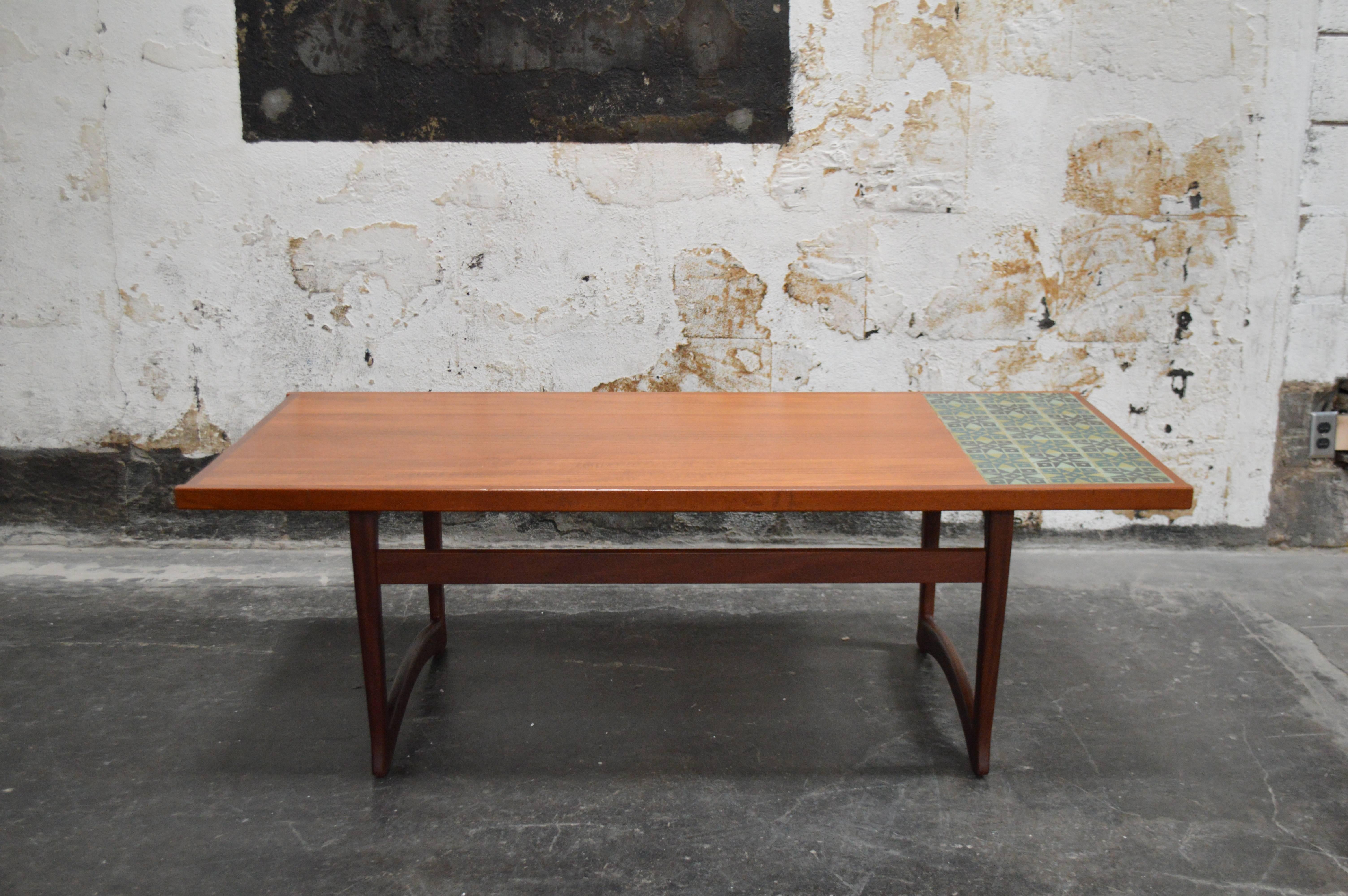 This handsome table is generously sized and very sturdy. It features a section of decorated tile in shades of green. The top is teak and the base is of mahogany which creates a nice contrast. Made by Ganddal Mobelfabrikk, circa 1960s. It has been