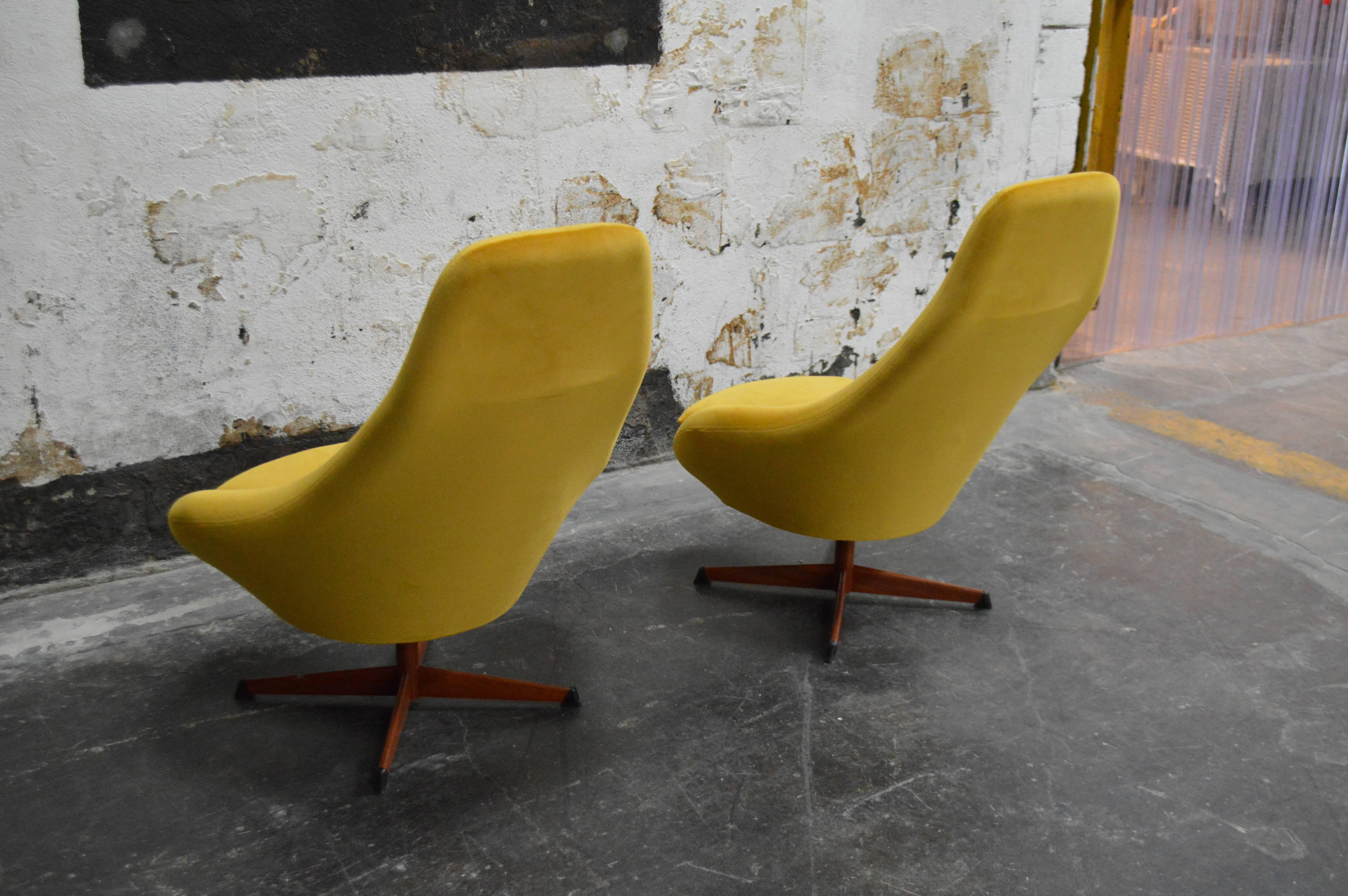 Fantastic pair of midcentury swivel chairs with teak veneered base. Restored and reupholstered in luxurious Pierre Frey mustard citron velvet. 

Dimensions:
31
