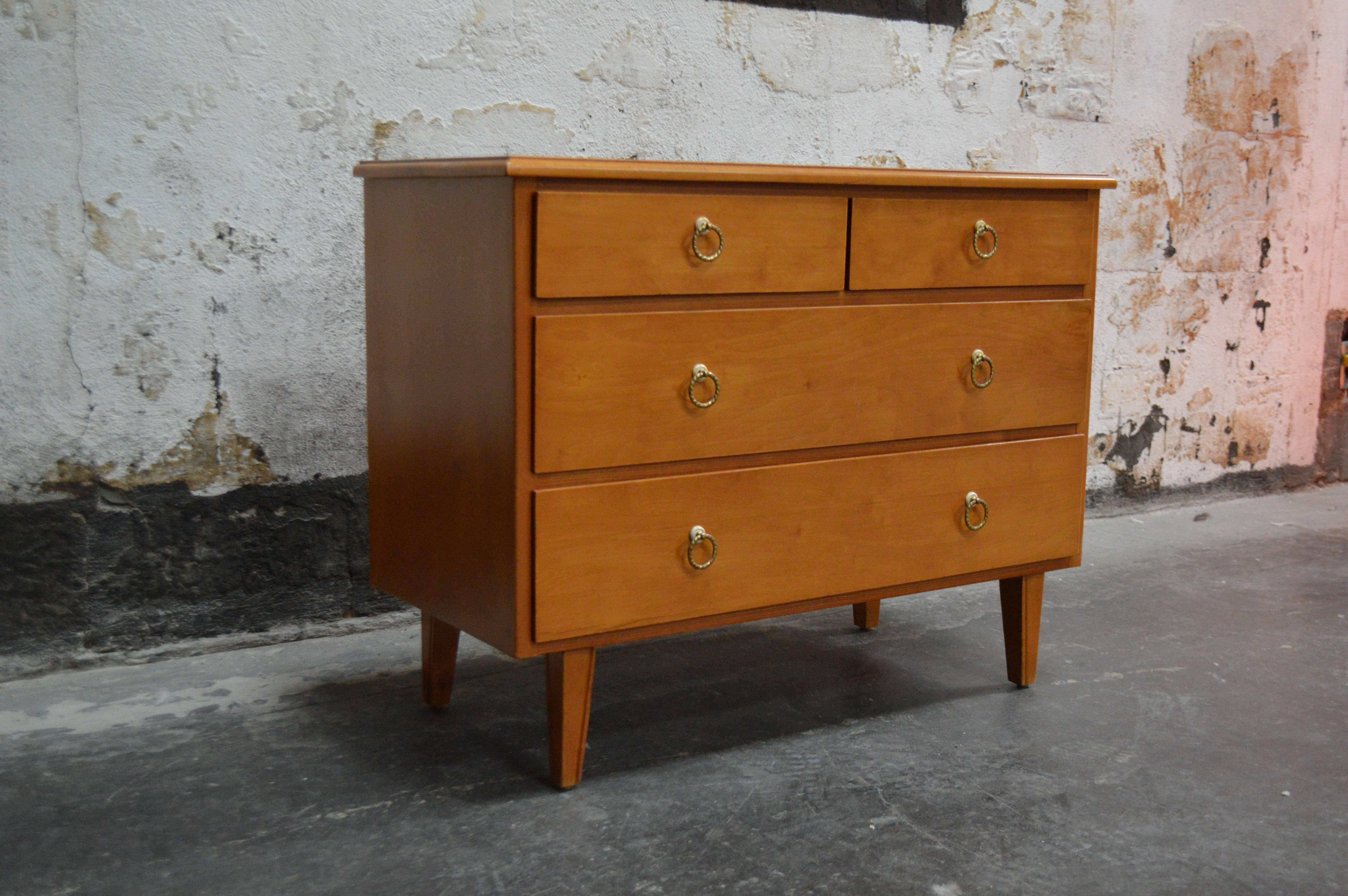 Handsome chest of drawers rendered in golden elm. Five dove-tailed drawers with ample storage. Twisted aged brass pulls with white bakelite details. Works nicely as a nightstand as well.