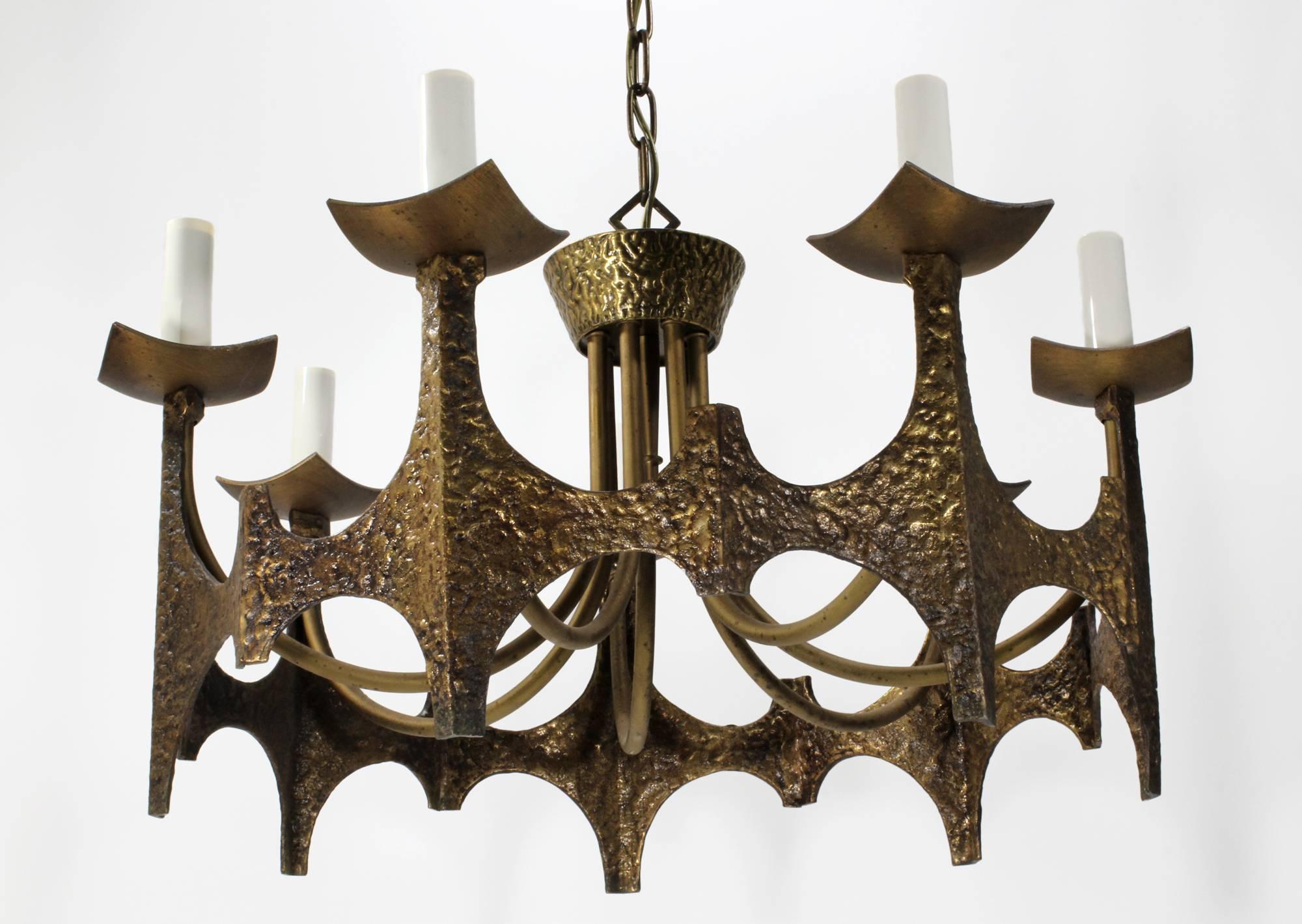 A seven-sided Brutalist chandelier in a crown motif made by Moe Light (American) in 1969. Cast and hammered solid brass construction with seven candelabra light sockets (E12, 40 watt max). Includes 19
