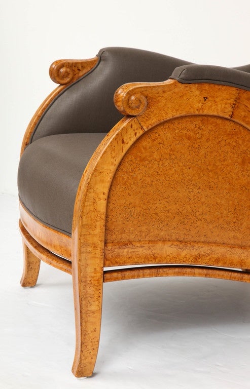 A Russian Karelian birch armchair, circa 1890-1910, of generous proportions, curved and upholstered backrest, partially padded scrolled armrests, recessed arched paneled sides raised on square tapered legs. 

Upholstered in Rogers and Goffigon