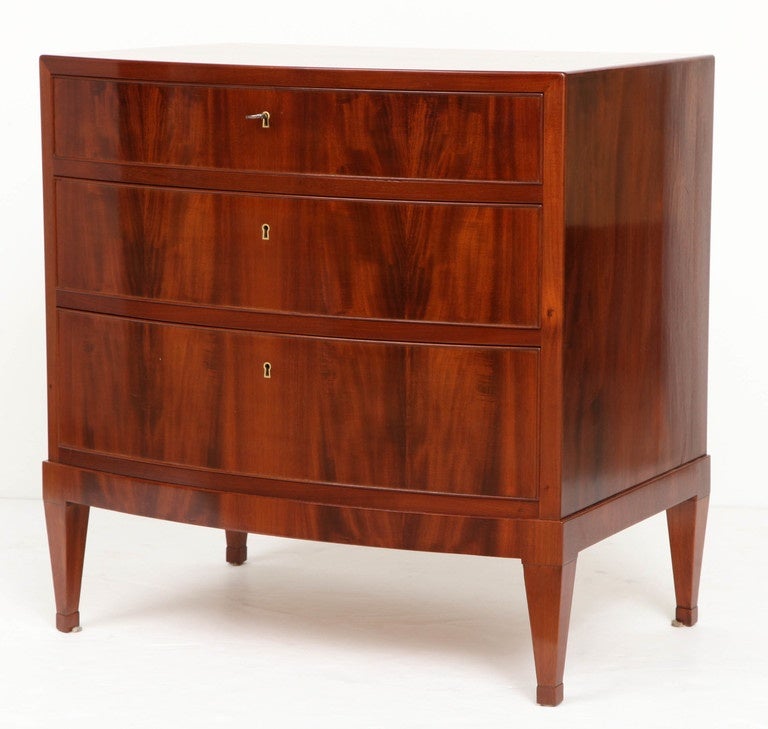 A Danish crotch mahogany bow-front chest of drawers, by Frits Henningsen, circa 1940s, the rectangular top with a bow front above three long drawers raised on square tapered legs ending with block feet.