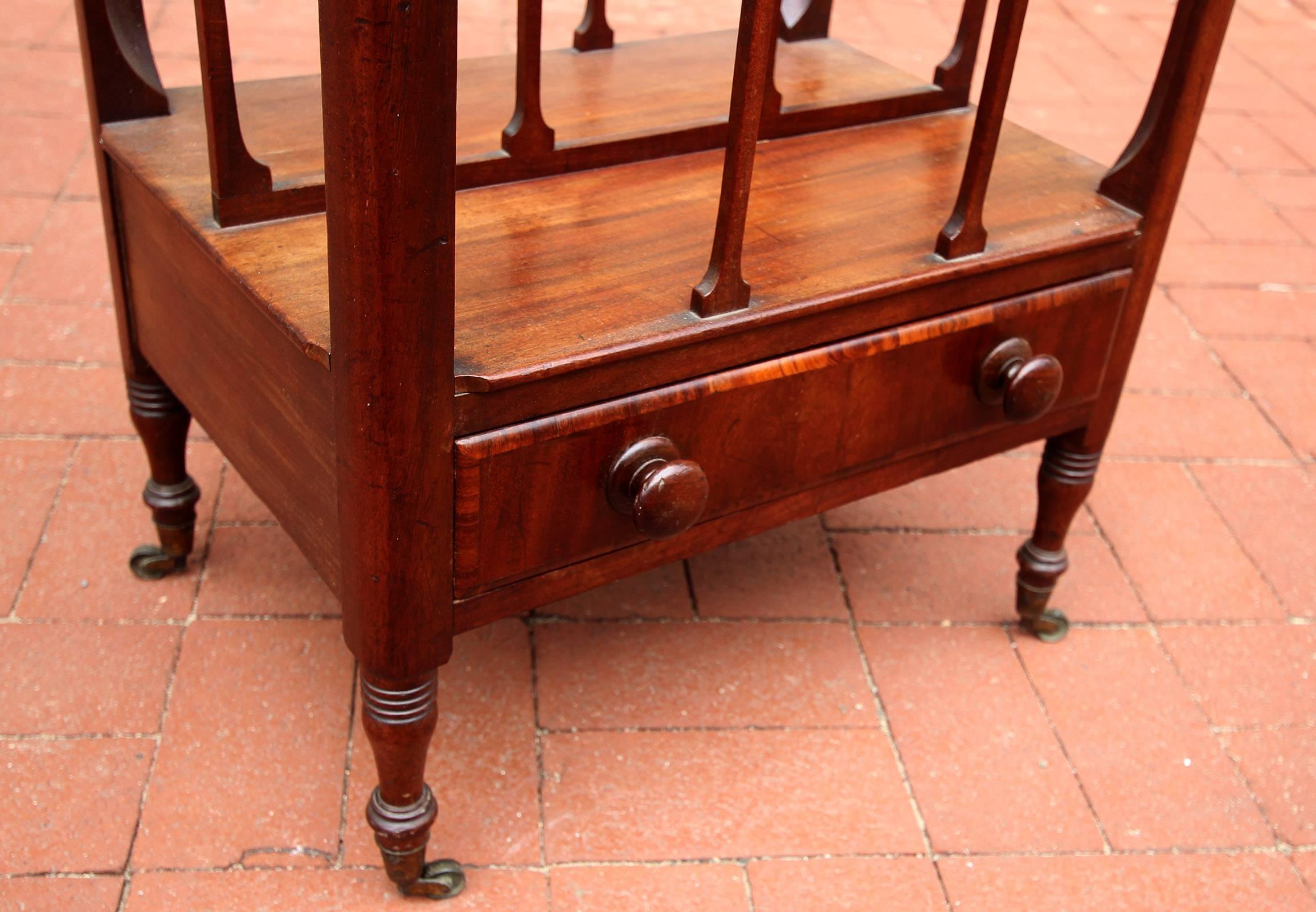 Fine mahogany Canterbury with one-drawer and two wide slots, English, circa 1830. Original finish and original casters.