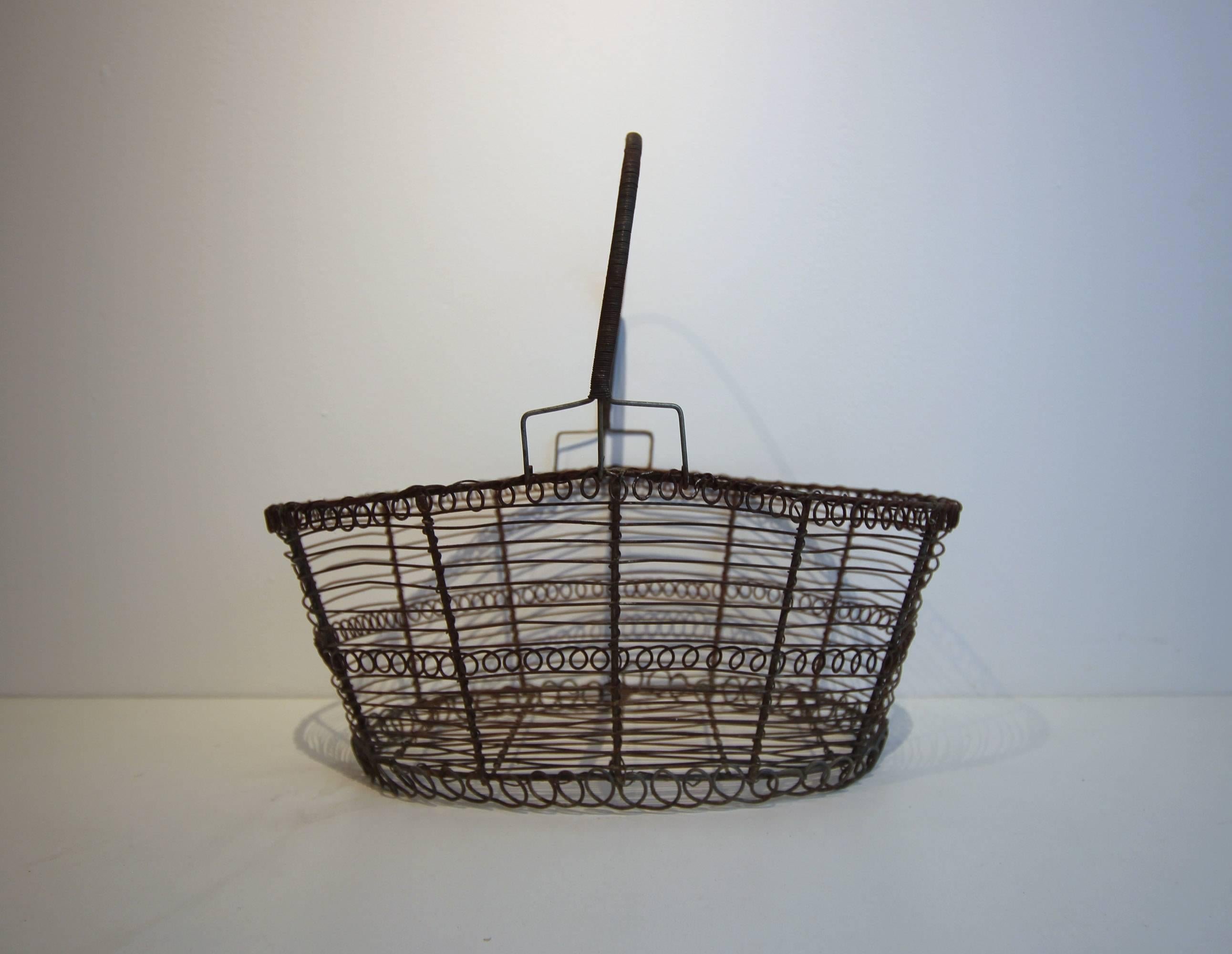 French wire basket with a tightly wound handle and great curlicue detail, circa 1900. Very sturdy, good patina.