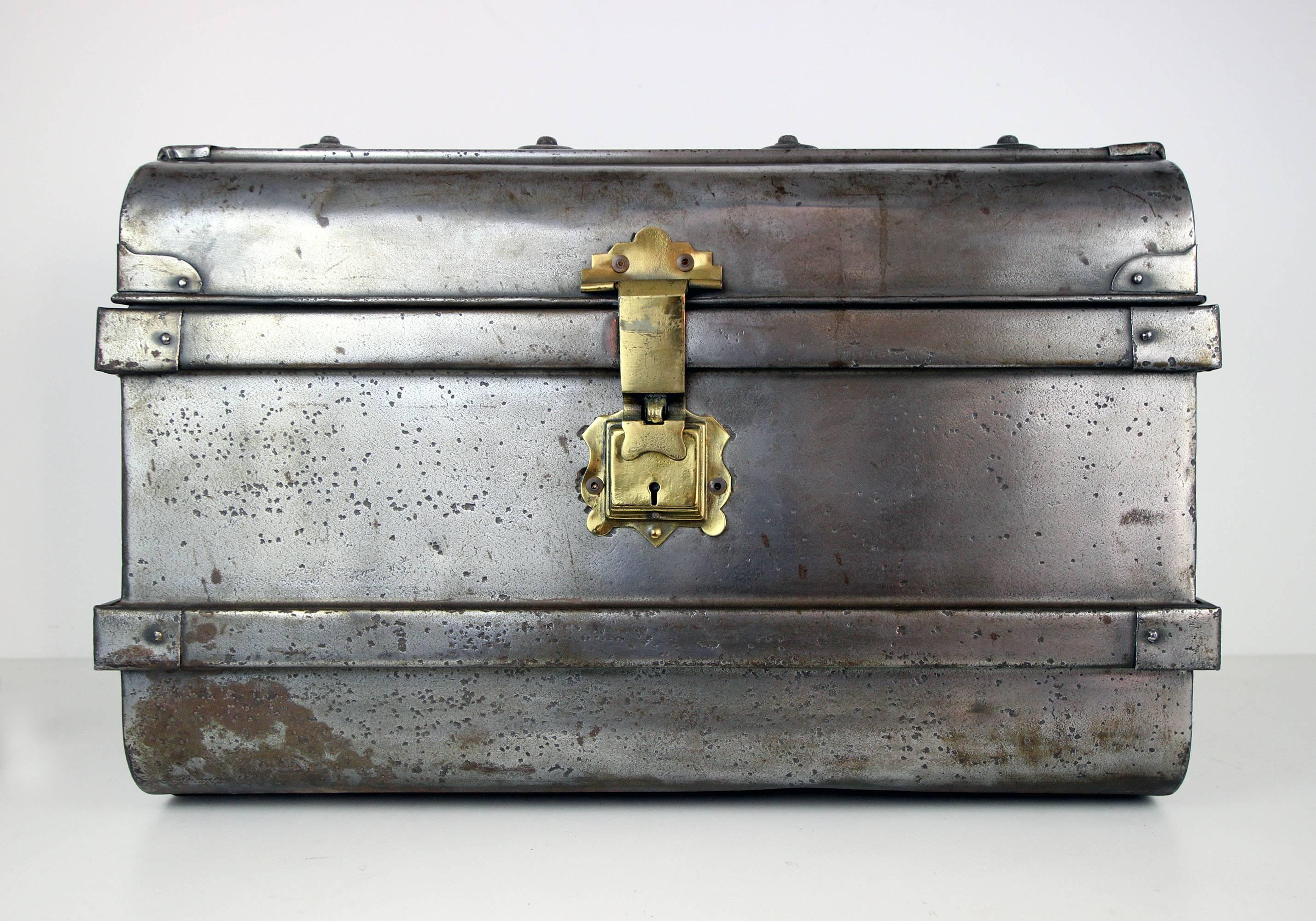 Fine nickel-plated steel trunk with strapping detail, heavy duty handles and original lacquered brass lock, russet brown painted interior. Very sturdy. Probably French, circa 1930.